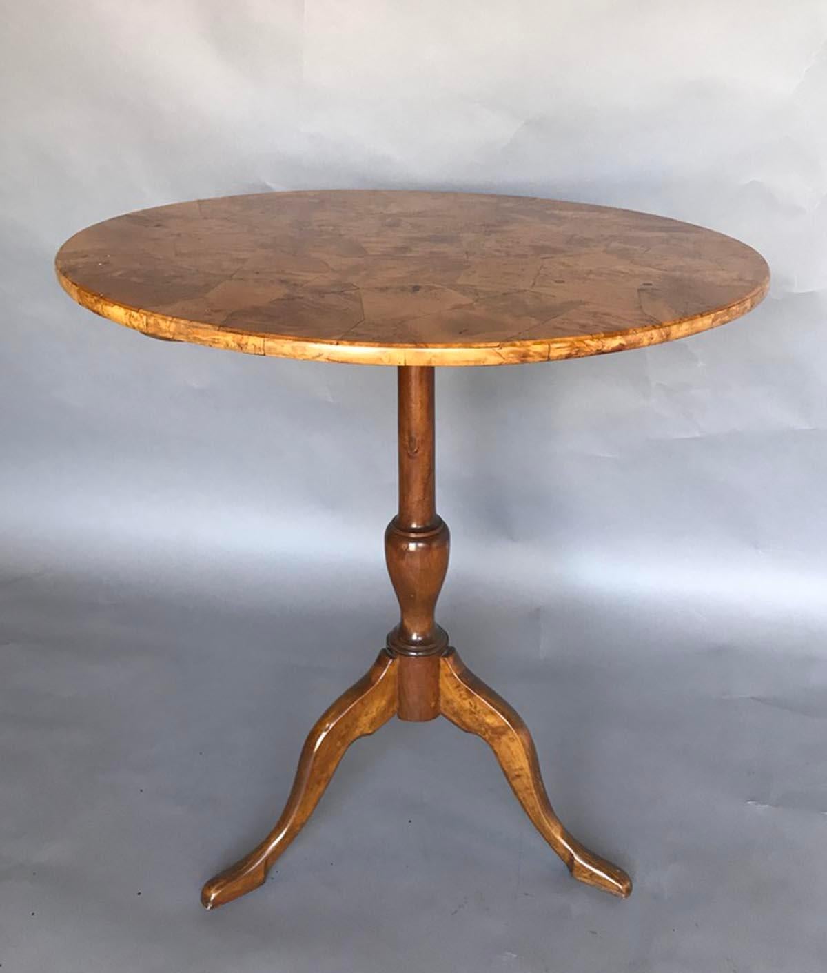 Turn of the 19th to 20th century French provincial tilt top table. Patchwork vibrant curly, flame birch top is a standout on a slender tripod pedestal base. In very good condition! Elegant and classic.