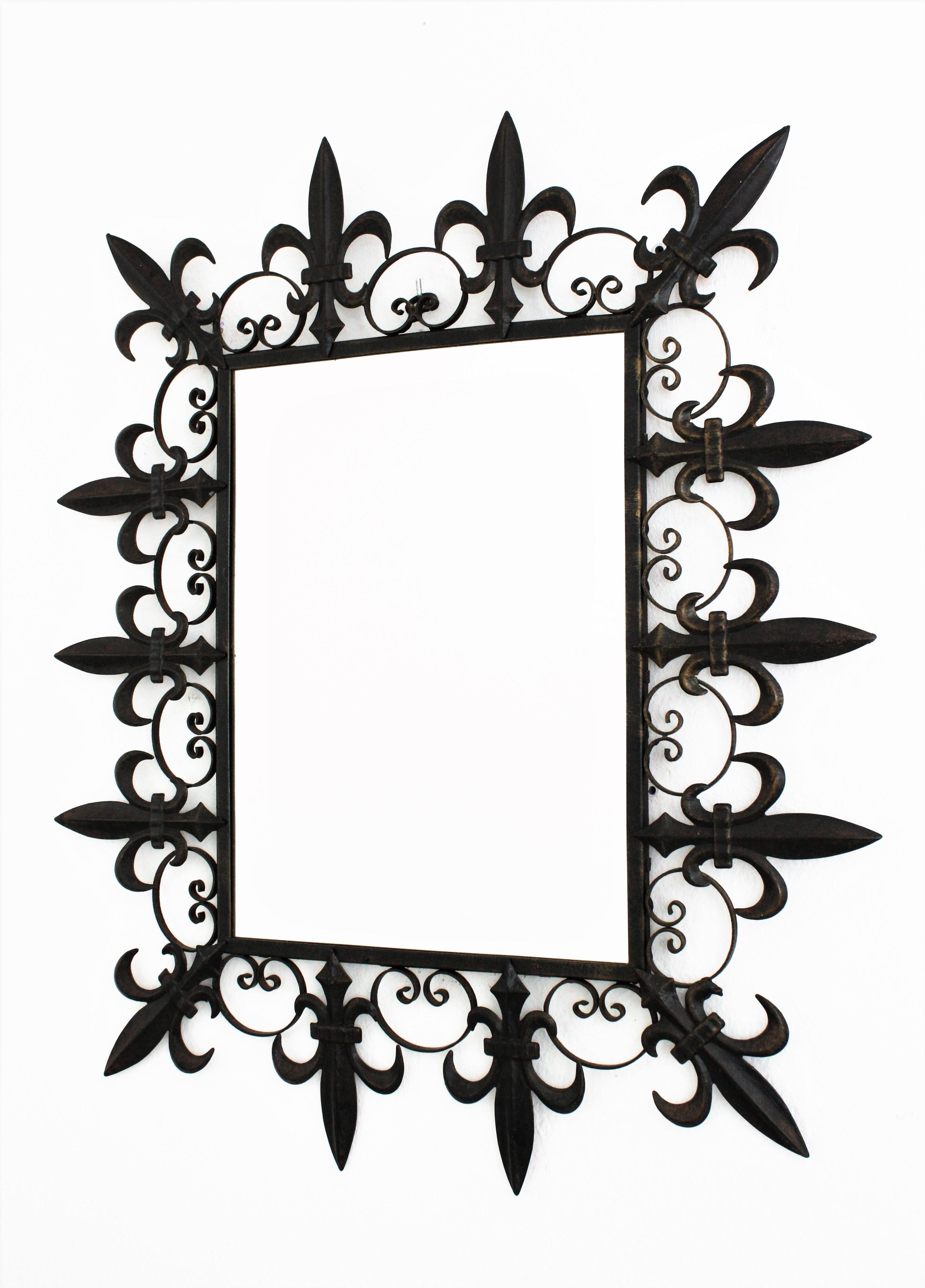 A hand-hammered iron wall mirror with fleur-de-lis and scroll motifs frame. France, 1930s
This mirror features a frame with alternating wrought iron fleur de lys and scroll details. It retains soft rests of its antique gold leaf gilding and has a