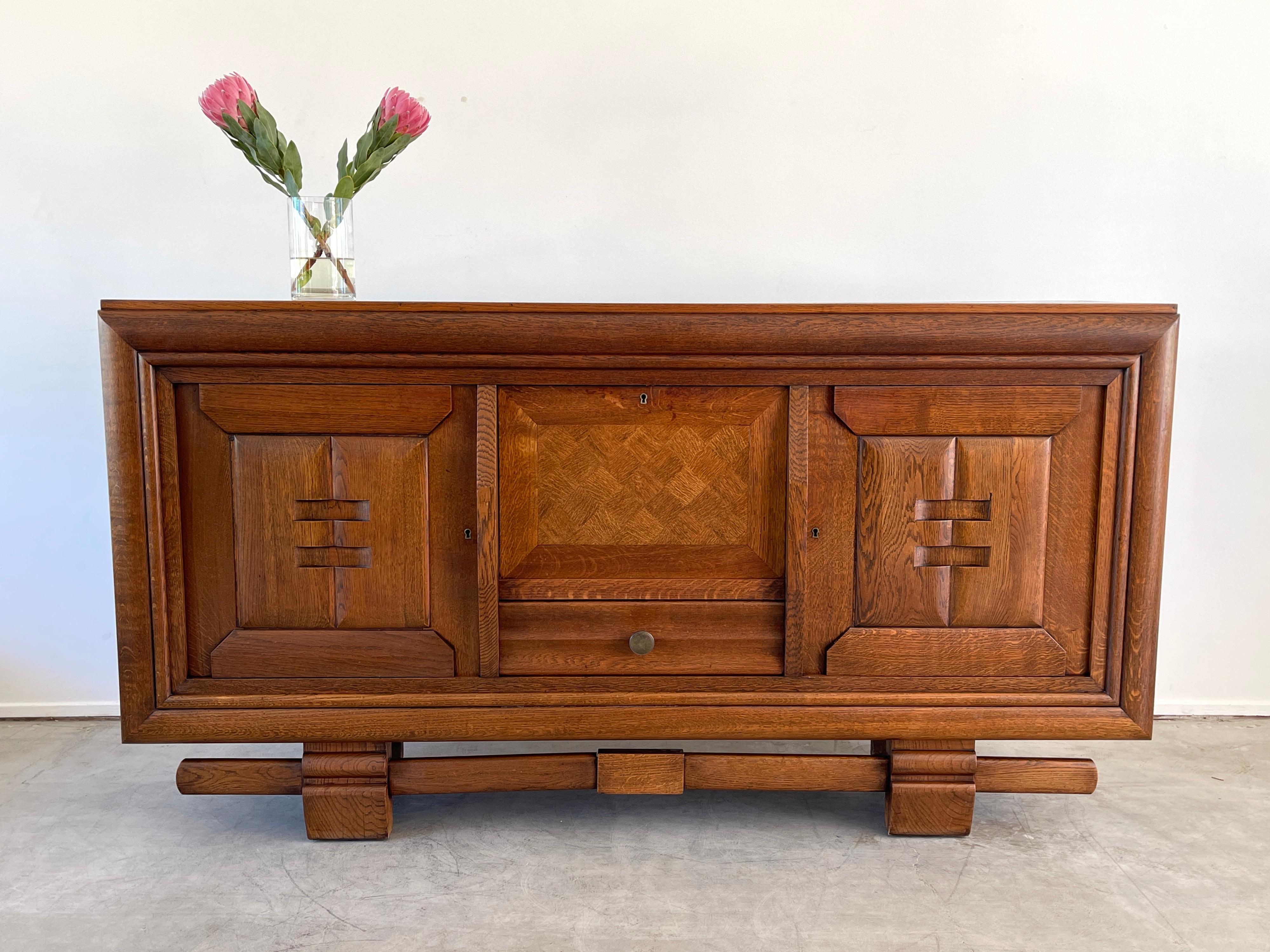 Beautiful 1940's French sideboard in the style of Charles Dudouyt
Beautiful parquetry top and floating base 
Key opens 2 doors to reveal open shelving and center drop down door to reveal glass mirrored shelf and lower drawer 
Incredible