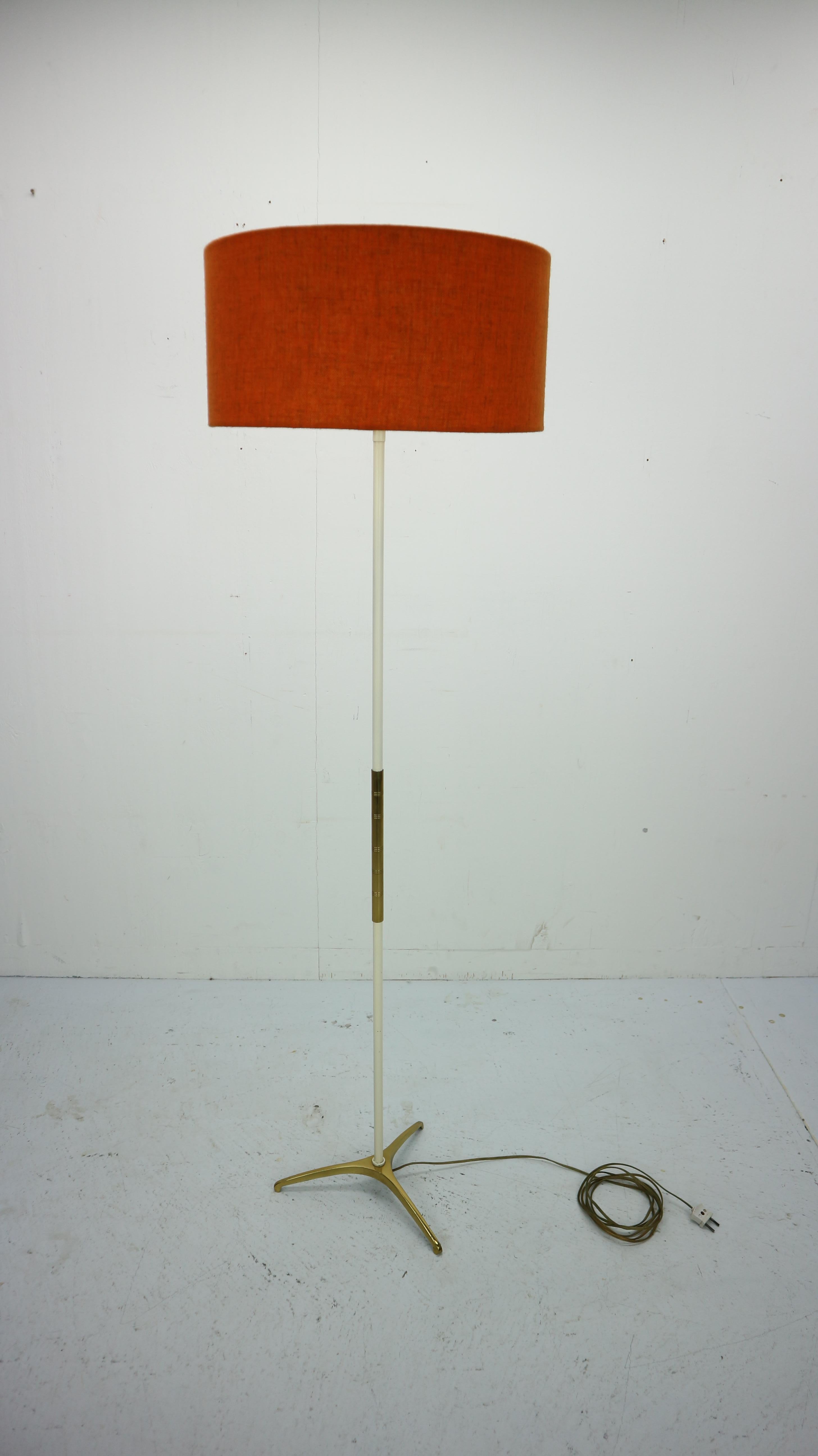 French floor lamp made of solid brass and metal, manufactured in the 1950s. All elements completely original, very high quality. 
The orange shade is in a beautiful condition.