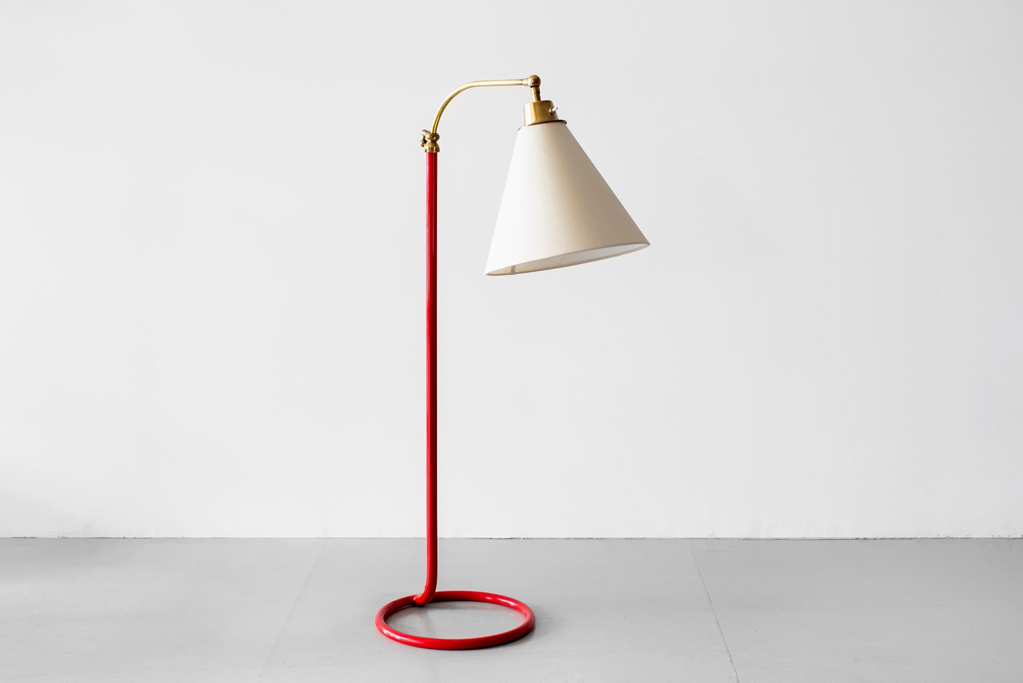 French floor lamp with red lacquered stem, pivoting brass neck and unique circle base. 
Adjustable height. 
Newly rewired with new silk shade.