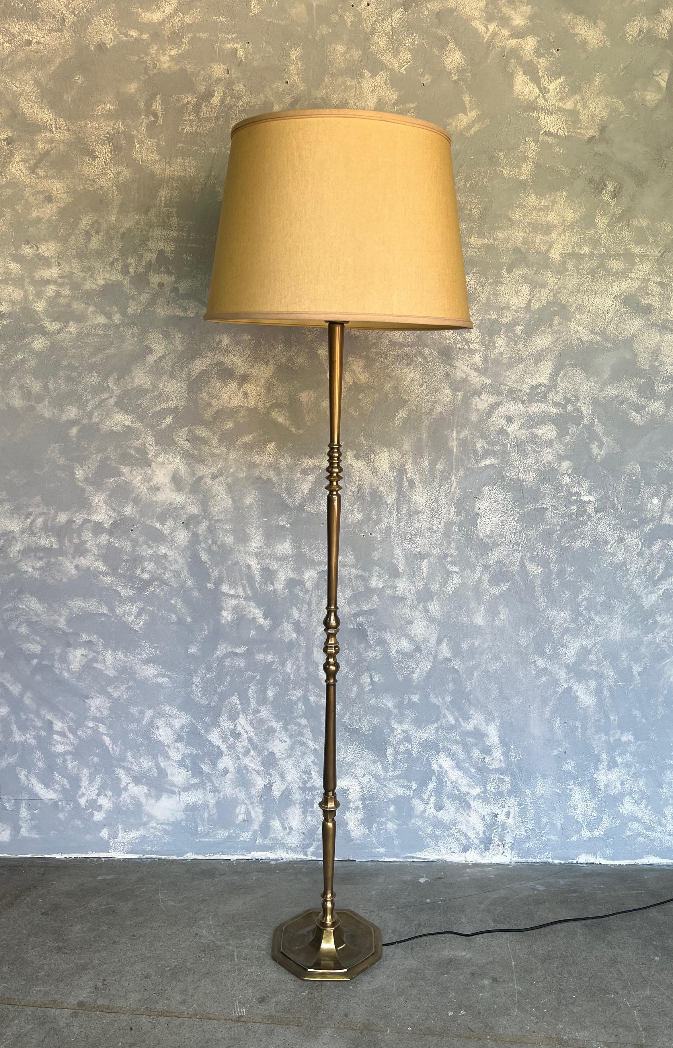 This impressive floor lamp hails from France, circa 1940s, and is a beautiful blend of brass and bronze. The lamp features turned and cast components that are elegantly assembled onto a hexagonal base, providing stability and a unique geometric