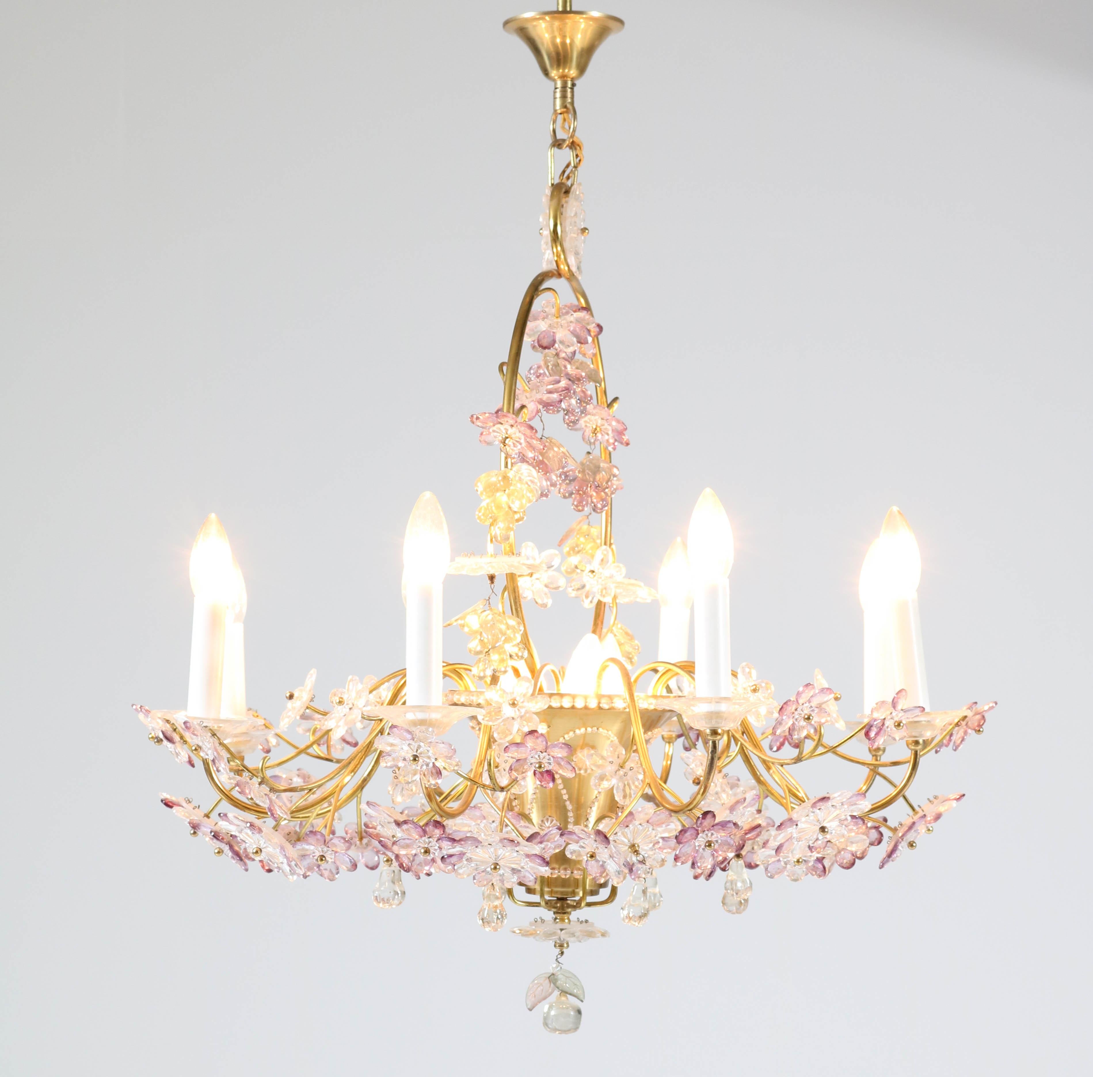 Magnificent and rare floral chandelier.
Design in the style Maison Baguès.
Striking French design from the 1950s.
Violet, pale green and clear crystal glass on gilt brass stems with a brass shade and ceiling cap.
Eleven sockets for E27