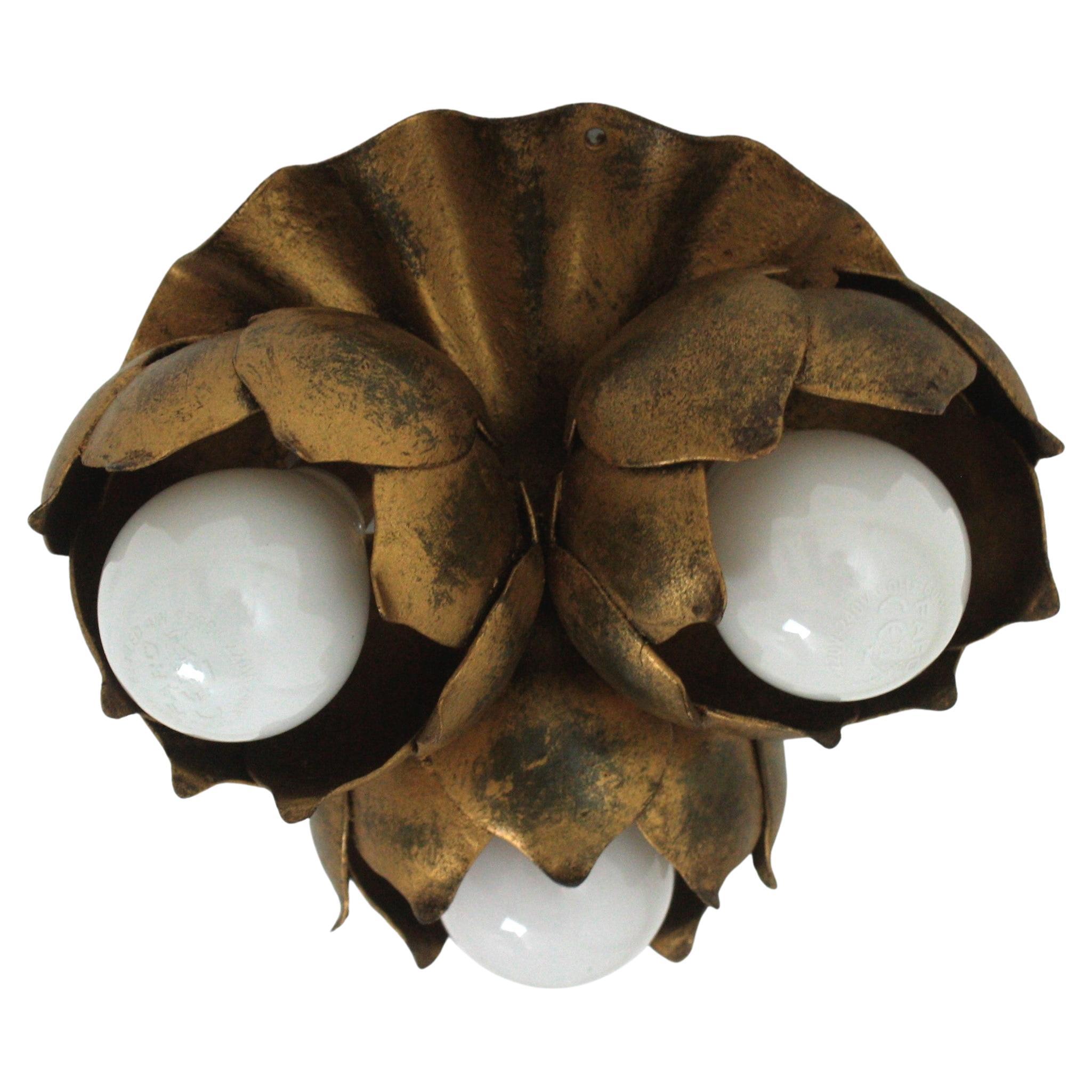 French 1940s gilt metal three light Floral Bouquet ceiling light fixture. 
A beautiful Hollywood Regency gilt wrought iron floral flush mount or wall sconce light. This lovely light fixture features a panel with three buds as bulb holders.