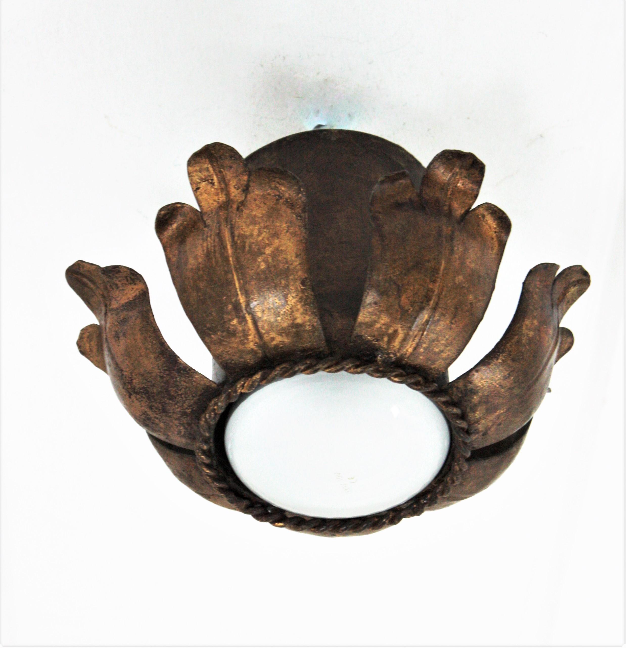 Eye-catching single flower bud/ tole flush mount light fixture in gold leaf gilt iron. France, 1940s.
This handwrought iron ceiling light fixture has a terrific aged patina showing its original gold leaf gilding.
It can be used as a flush mount,