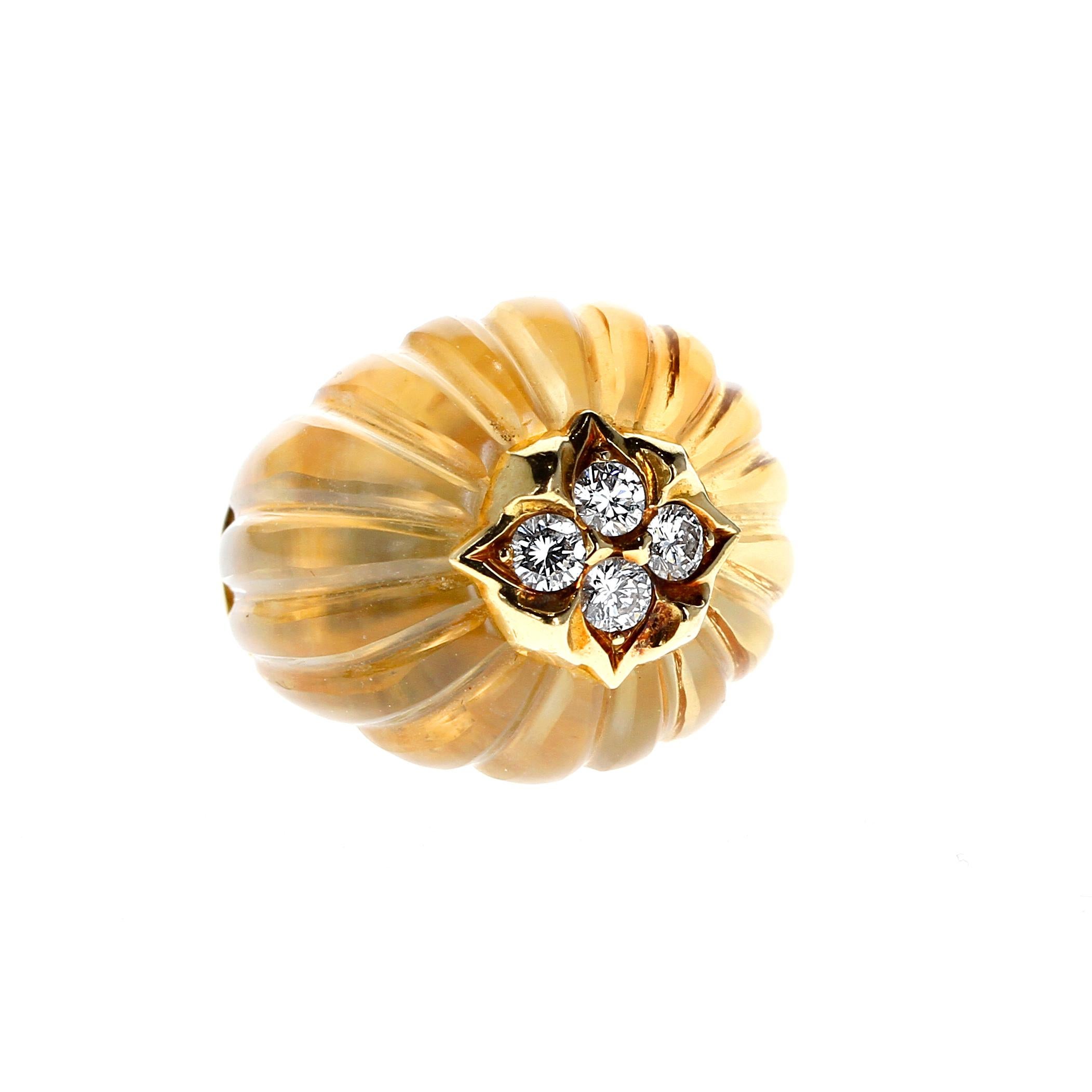 A masterfully hand-crafted ring, set with a fluted tapered citrine cabochon centered with a floral motif encrusted with four round brilliant-cut diamonds. The ring is stamped with marker's marks and French assay marks; size 6 US with ring guard