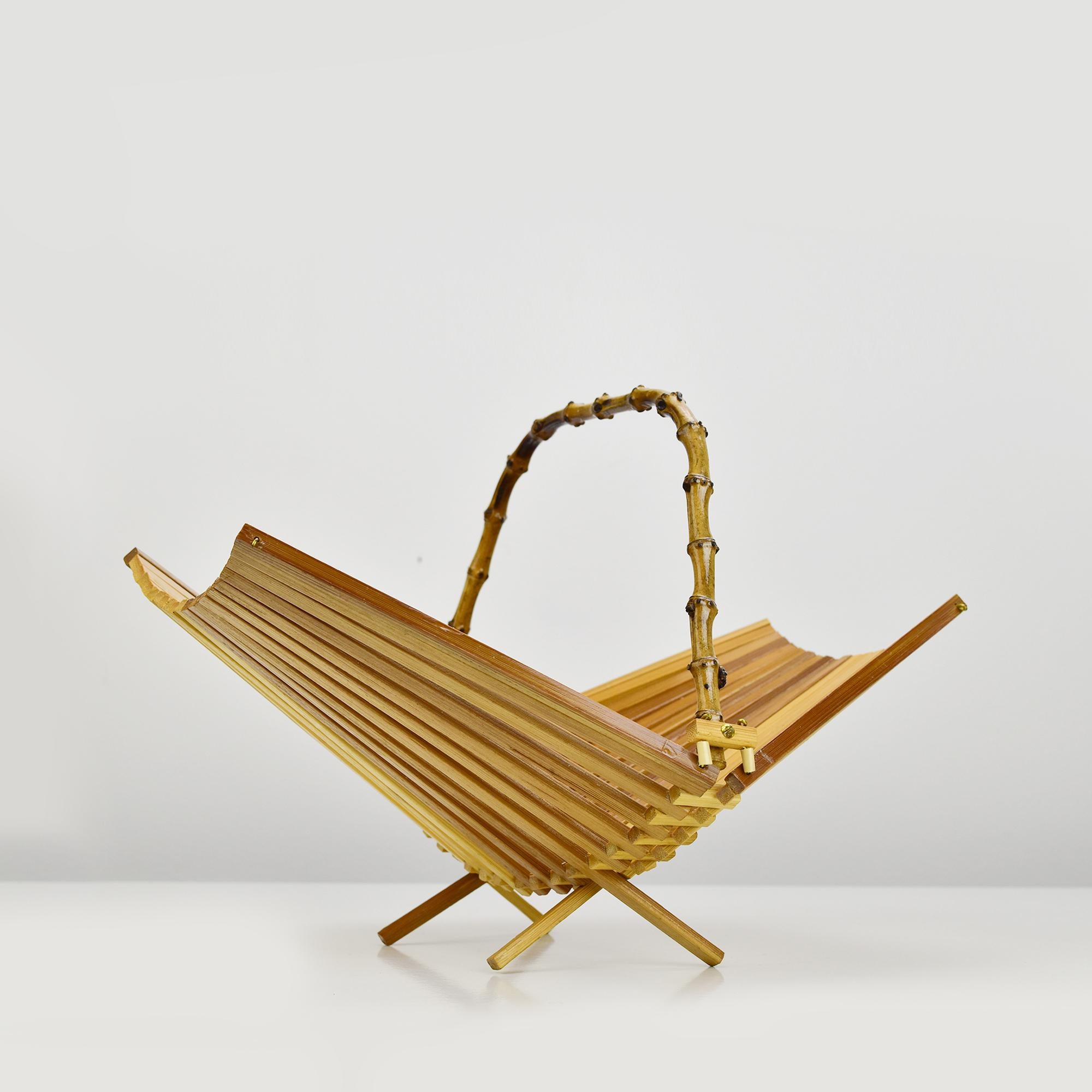 Questo bellissimo e pratico cesto di frutta, realizzato in legno pieghevole negli anni '60 e probabilmente prodotto in Francia, presenta una forma geometrica semplice e un design senza tempo. È perfetto per essere conservato ed è realizzato in fibra