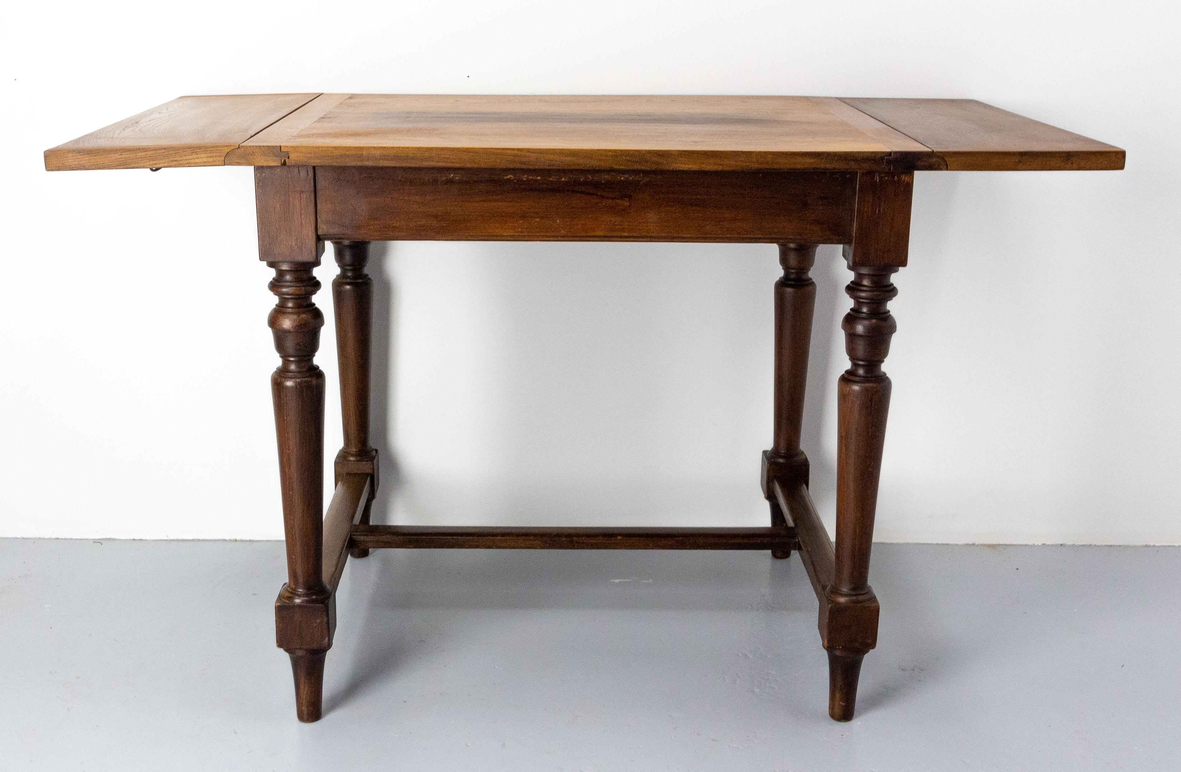 Little chestnut dining table. The two end are foldable and the little width of this table is 32.28 in. (82 cm) 
The table top was made circa 1970. It was laid on a beech base dating of the late 19th century.
Good antique condition, with signs of