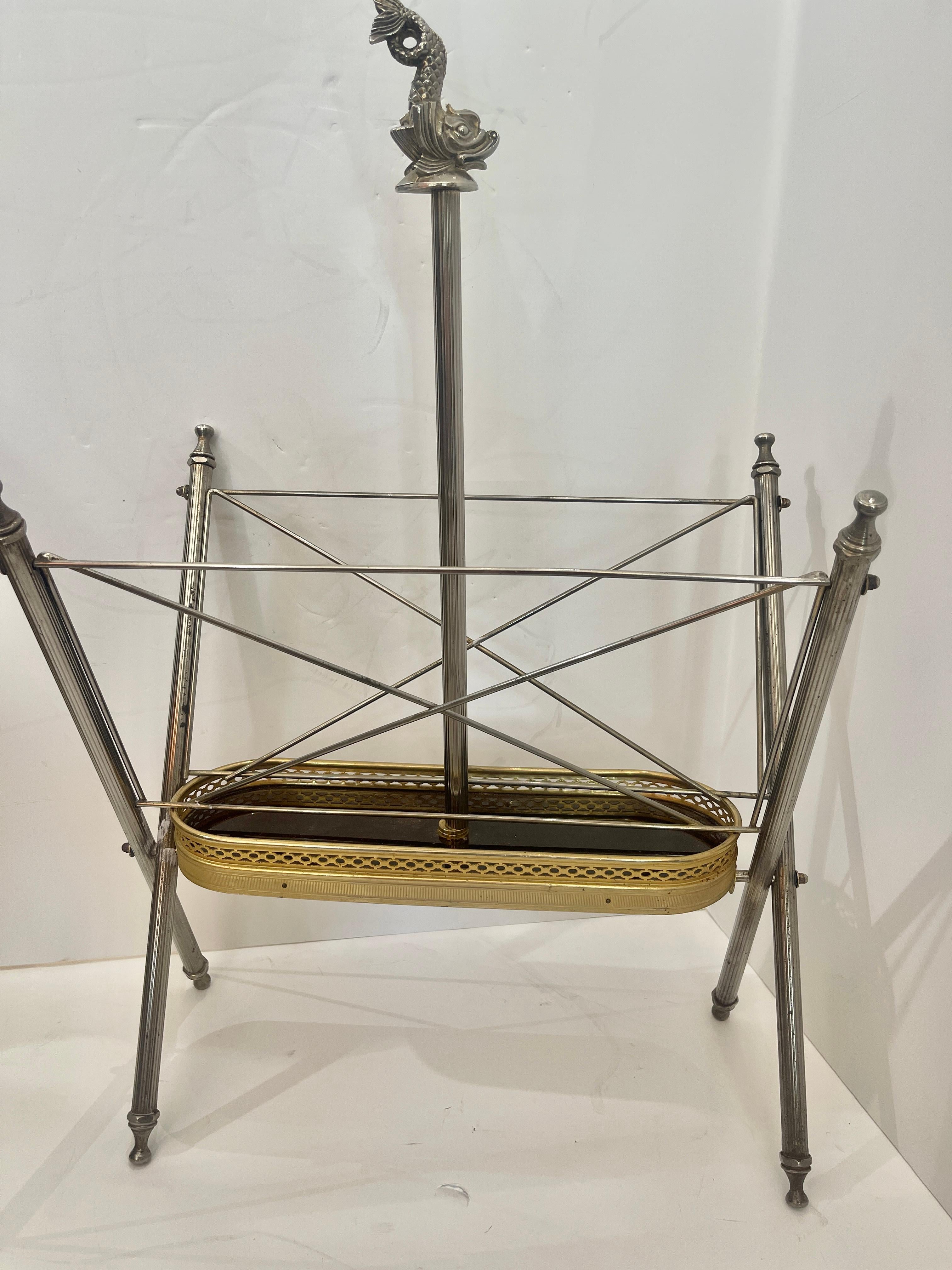 This is a very elegant and useful French Folding Magazine Rack, in the Neoclassical Style  in Gilt Metal & Silver Plate C. 1950.
The base has a stunning Gilt metal gallery with a mahogany bottom.
The cross legs end with a very nice finial top and