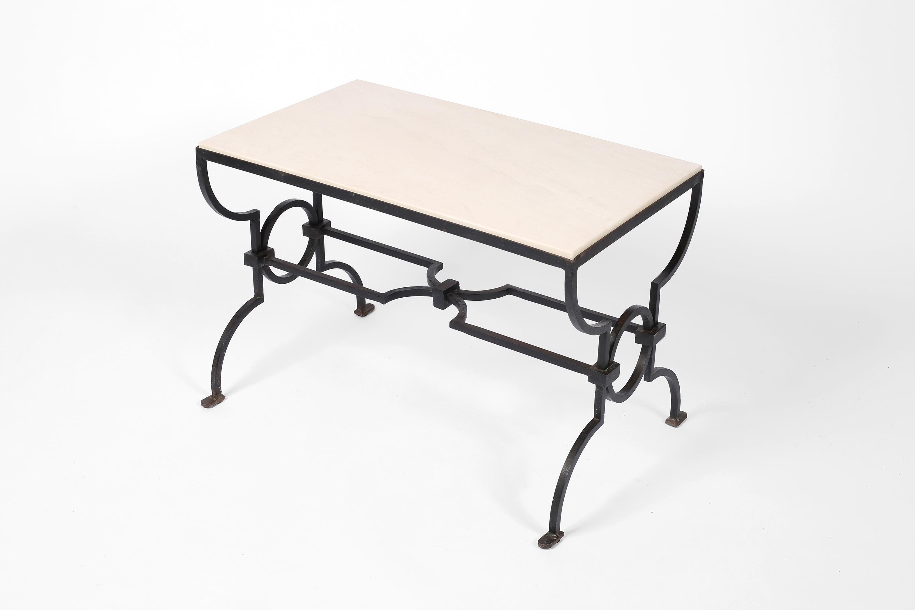 A forged iron and limestone coffee table by Gilbert Poillerat (1902-1988), from a drawing by Jacques Adnet (1900-1984). French, c. 1940.