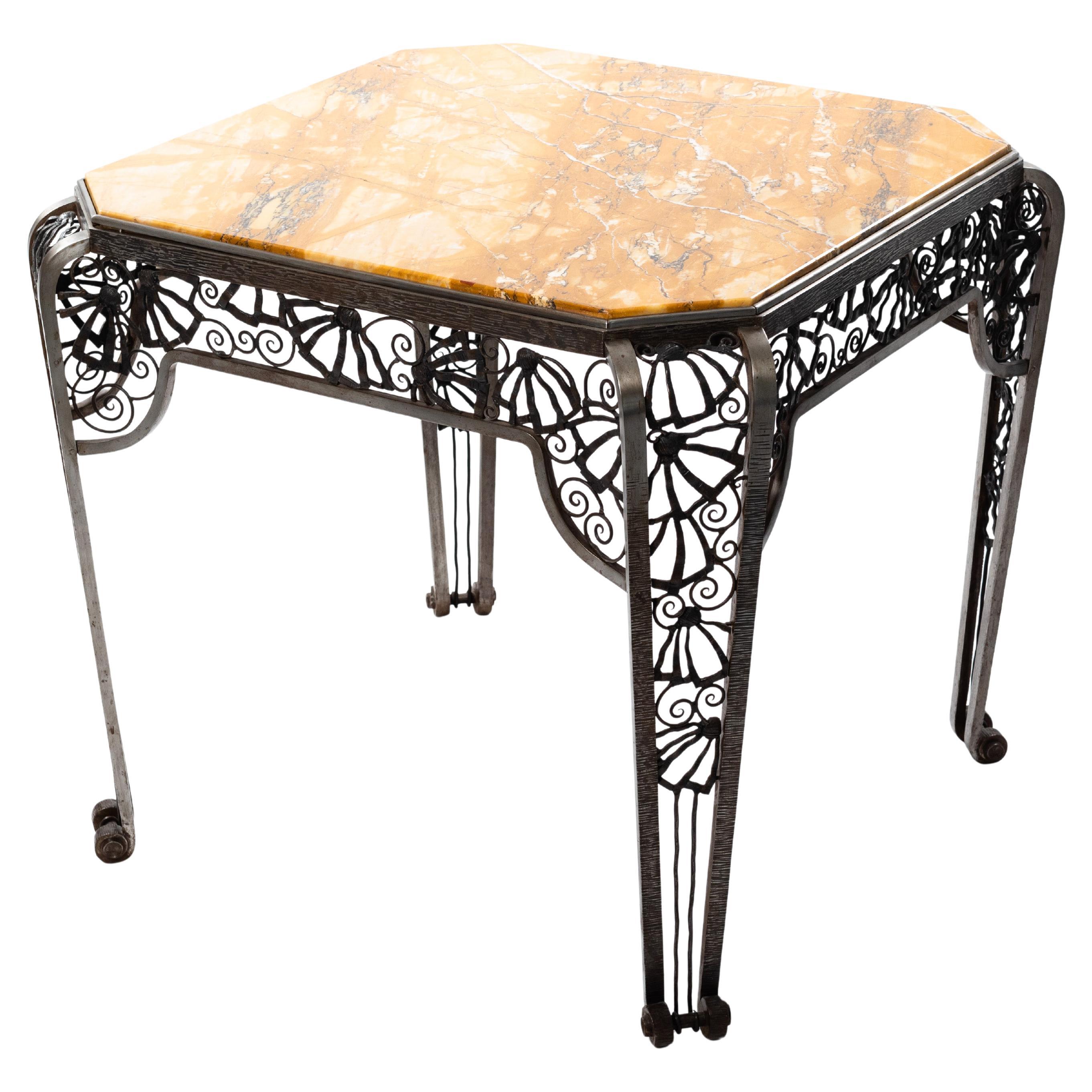 French Art Deco center table in forged iron with mustard colored marble top.

This exceptional table by Malatre et Tonnelier is a handcrafted work of art and an absolute eye-catcher.
The table is octagonal and the 4 curved legs end in a volute at