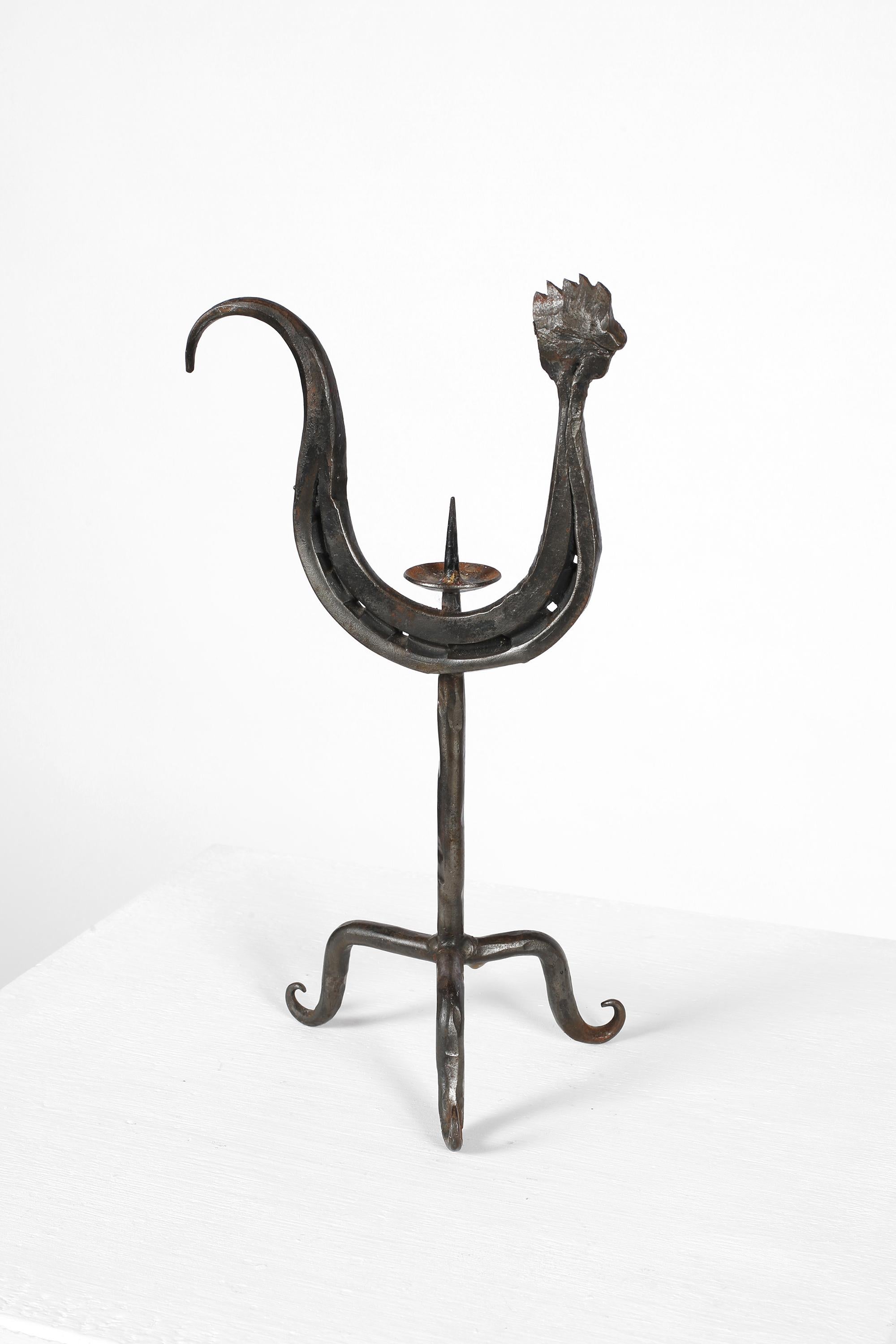 Candelero zoomorfo de hierro forjado a mano estilizado como un gallo sobre una base de tres puntas. A la manera de las obras de Jean Touret y Les Artisans de Marolles. Francés, c. 1950s. 