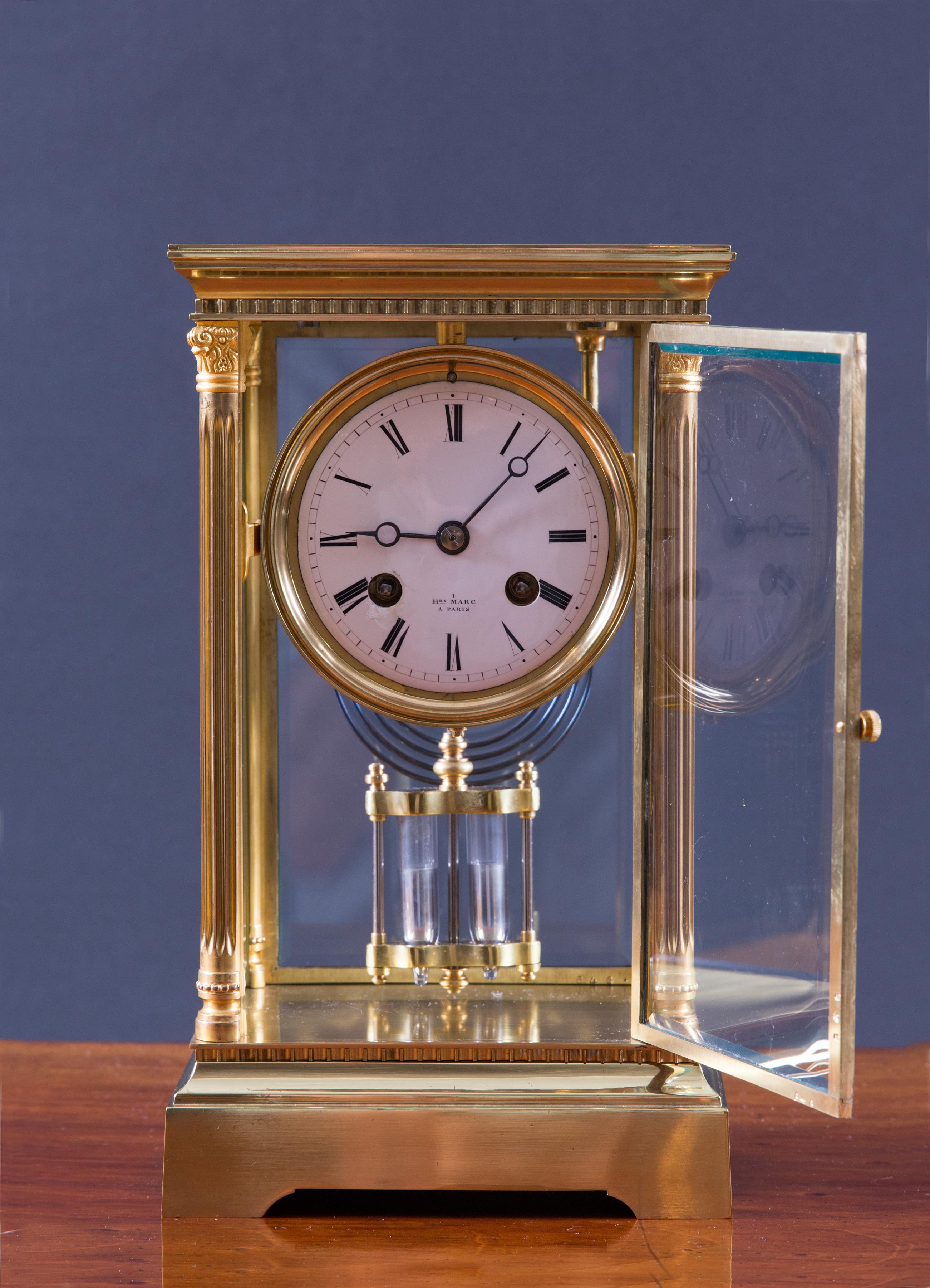 French four glass mantel clock with reeded pillars and Corinthian capitals with dentil moulding. Bevelled glass panels, enamel dial with Roman numerals signed Henri Marc, Paris. 

 Eight day movement with outside countwheel striking the hours and