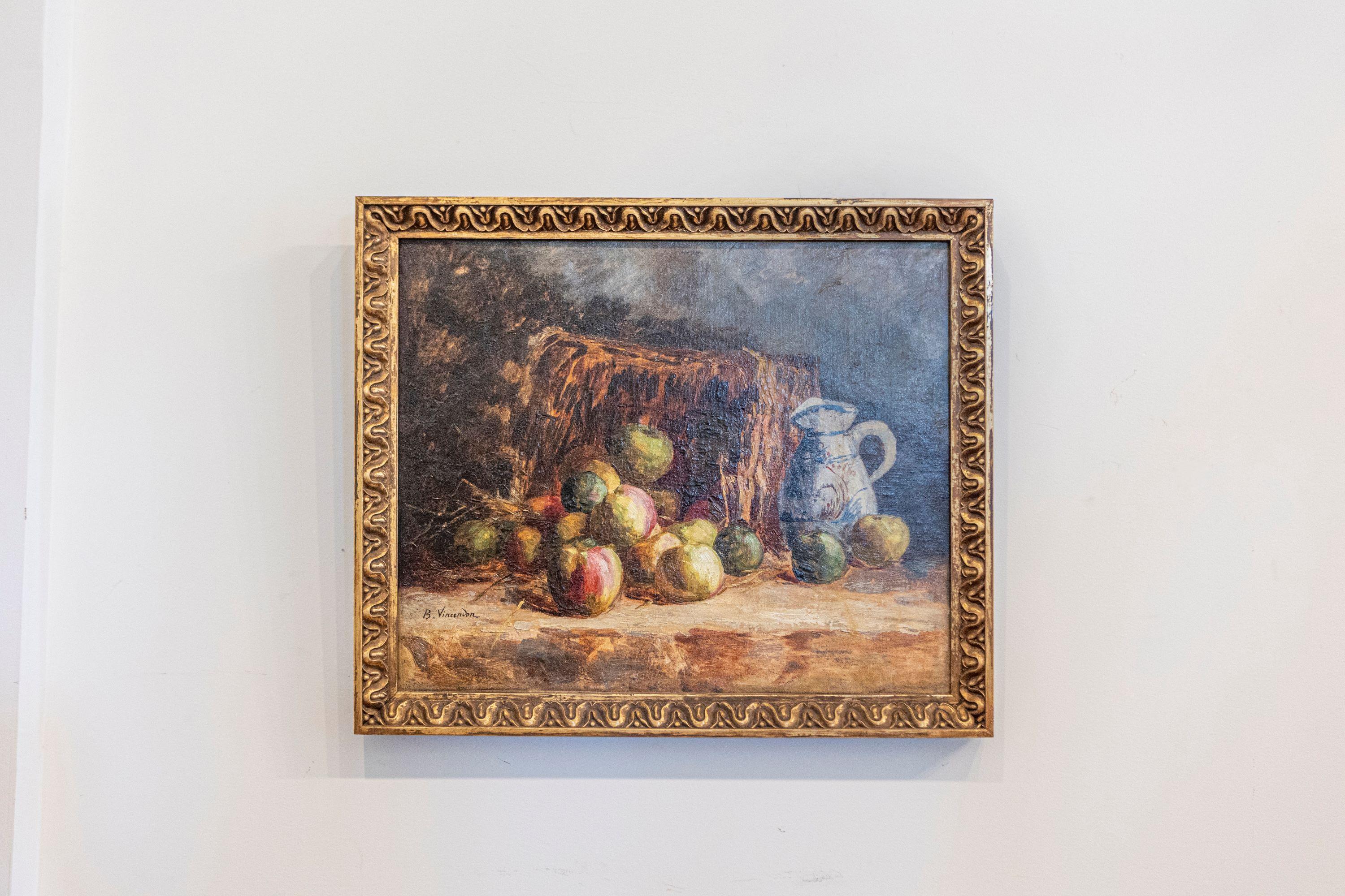 A French medium size still life oil painting signed by Berthe Vincendon from the late 19th century, depicting fruits and a pitcher. Set within a richly carved giltwood frame, this French painting features a basket with fruits and pitcher. Occupying