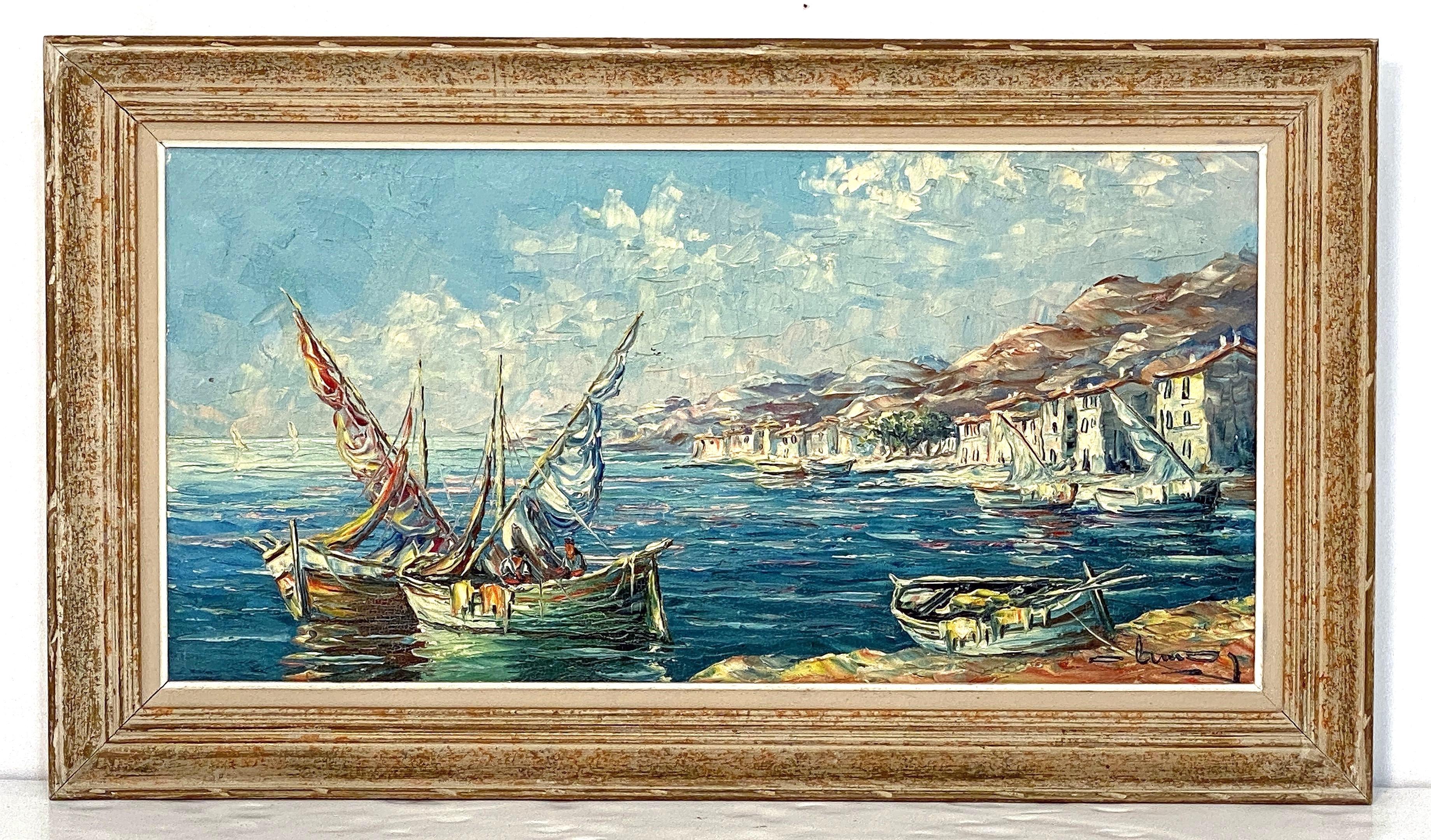 Pregevole dipinto francese a olio su tela raffigurante una scena di porto del Mediterraneo, con una vista di barche a vela e una pittoresca cittadina in stile impressionista, firmato nell'angolo in basso a destra, montato in una cornice rettangolare