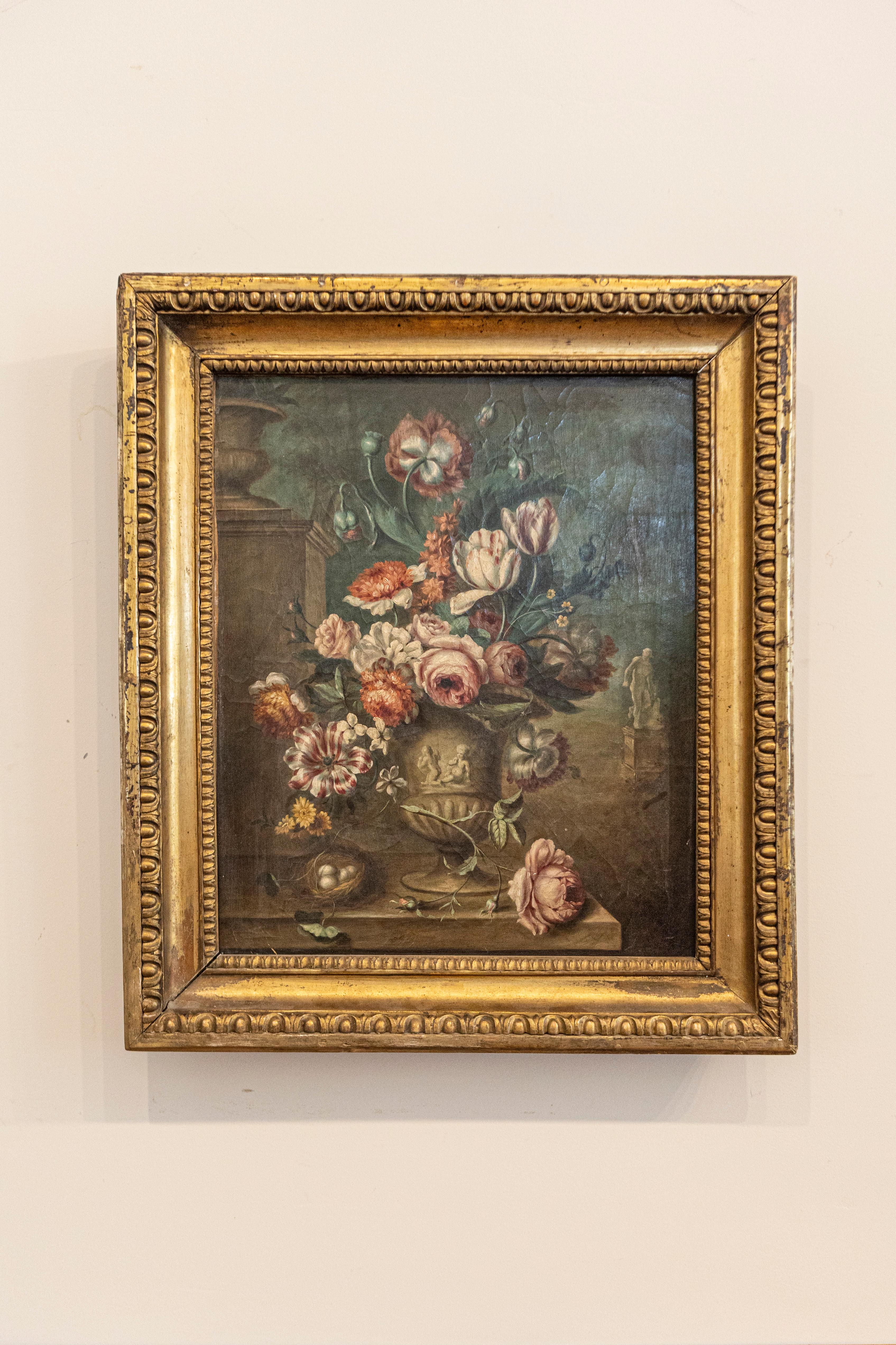 A French framed oil on canvas still-life painting from the mid-19th century, depicting a colorful bouquet of flowers in a vase, set in a carved giltwood frame. Born in France at the beginning of Emperor Napoleon III's reign, this vertical oil on