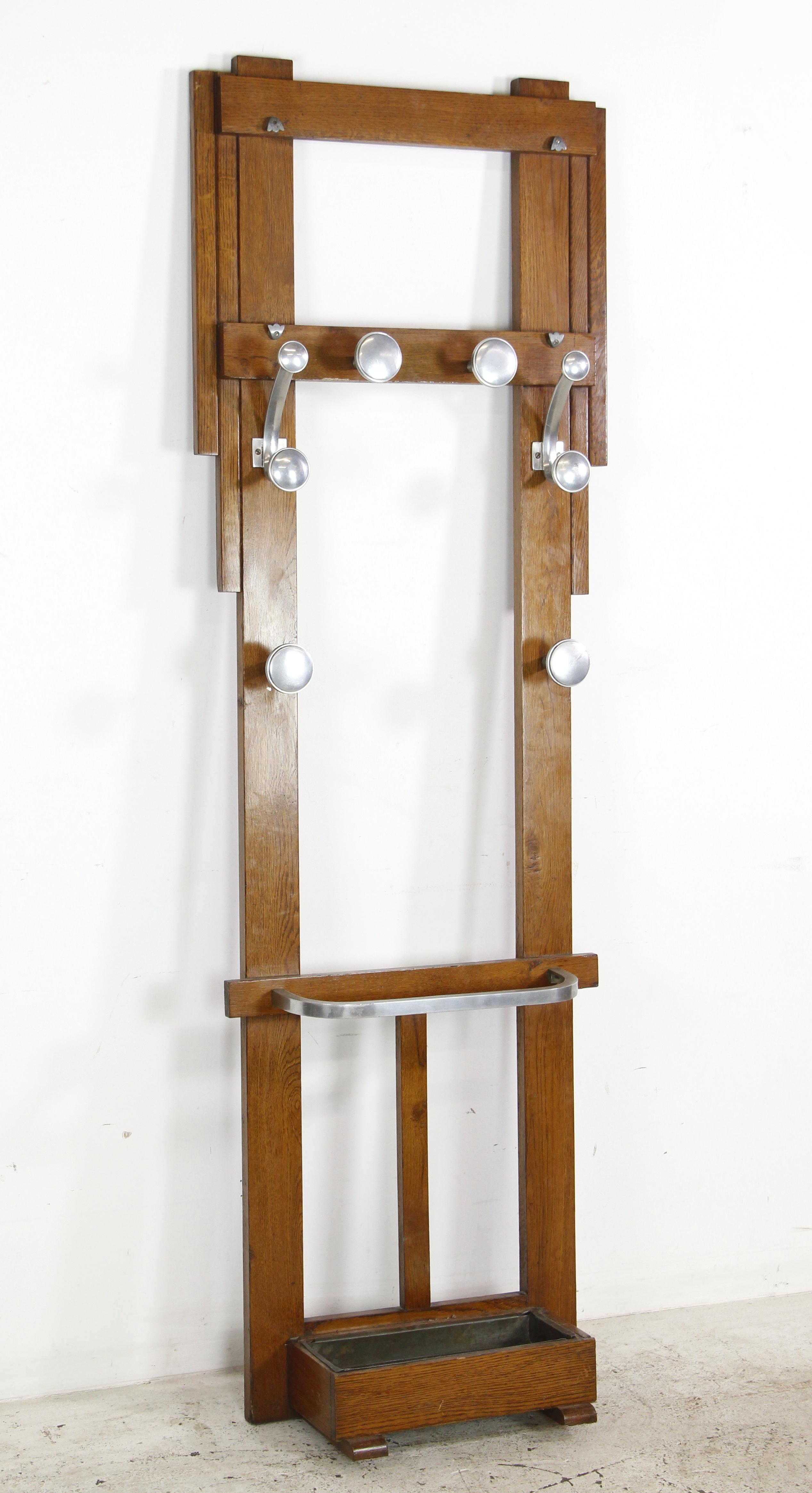 Cet arbre d'entrée européen sur pied est fabriqué en chêne scié sur quartier. Il est doté de crochets uniques en aluminium et d'une cuvette à la base pour permettre aux parapluies de s'égoutter. Un disponible. Veuillez noter que cet article se