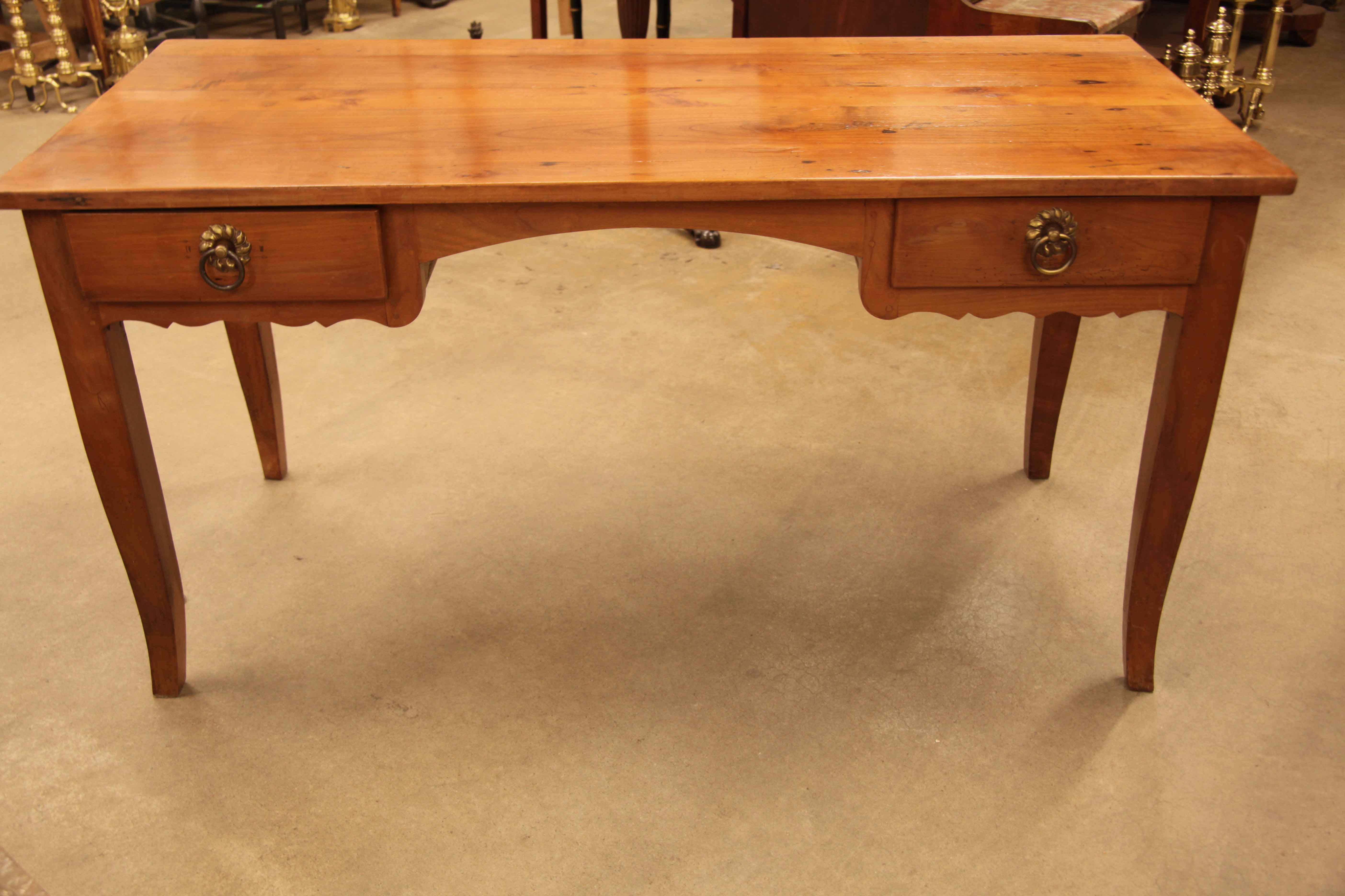French fruit wood two drawer desk or writing table, the top has outstanding color and patina ; the two drawers with ring pulls and overlapping edges over scalloped aprons, center with arched apron with plenty of sitting clearance The square legs