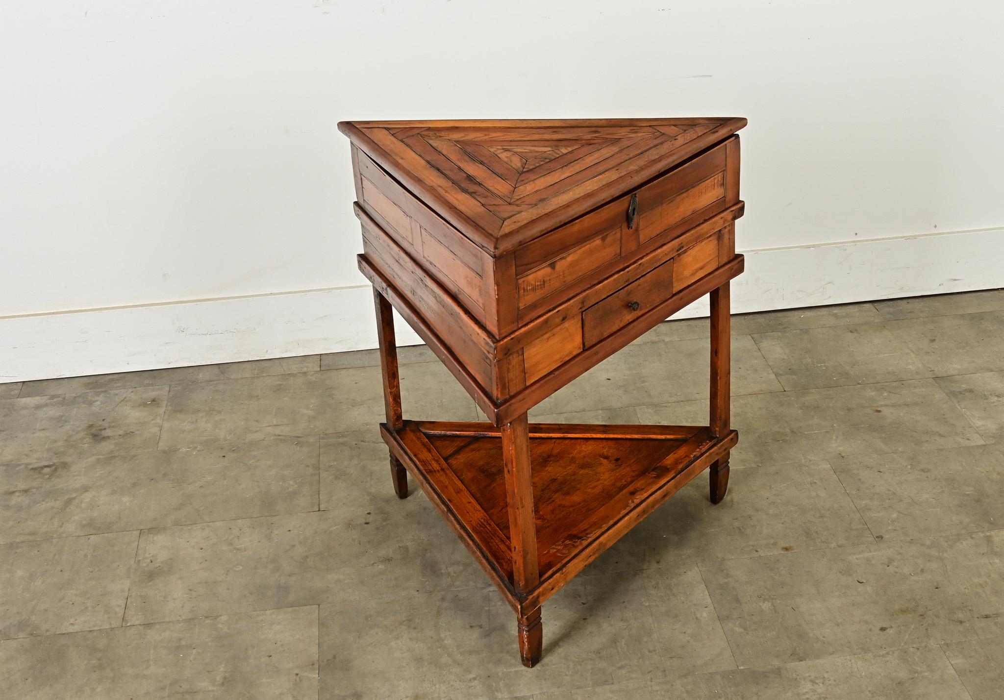 A most unusual 19th century French corner table of three sides, assembled from fruitwood. By arranging the fruitwood marquetry in concentric triangles on the top, the artist has highlighted the variety of warm tones and figural grain patterns with a