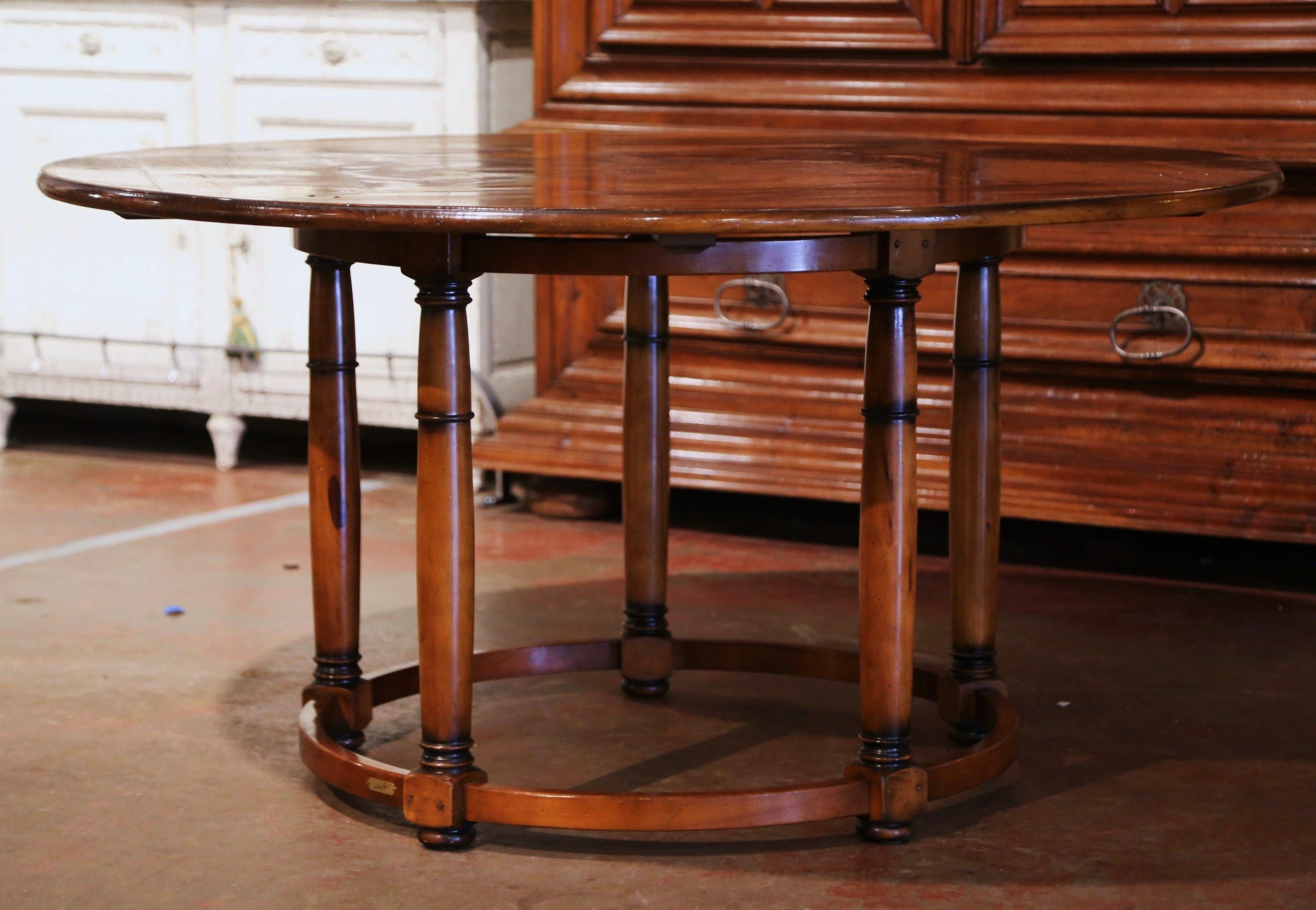 Decorate a breakfast room or game room with this elegant vintage table. Crafted in France circa 1980 and almost six foot in diameter, the table stands on five turned legs ending with bun feet over a bottom circular stretcher signed by the cabinet