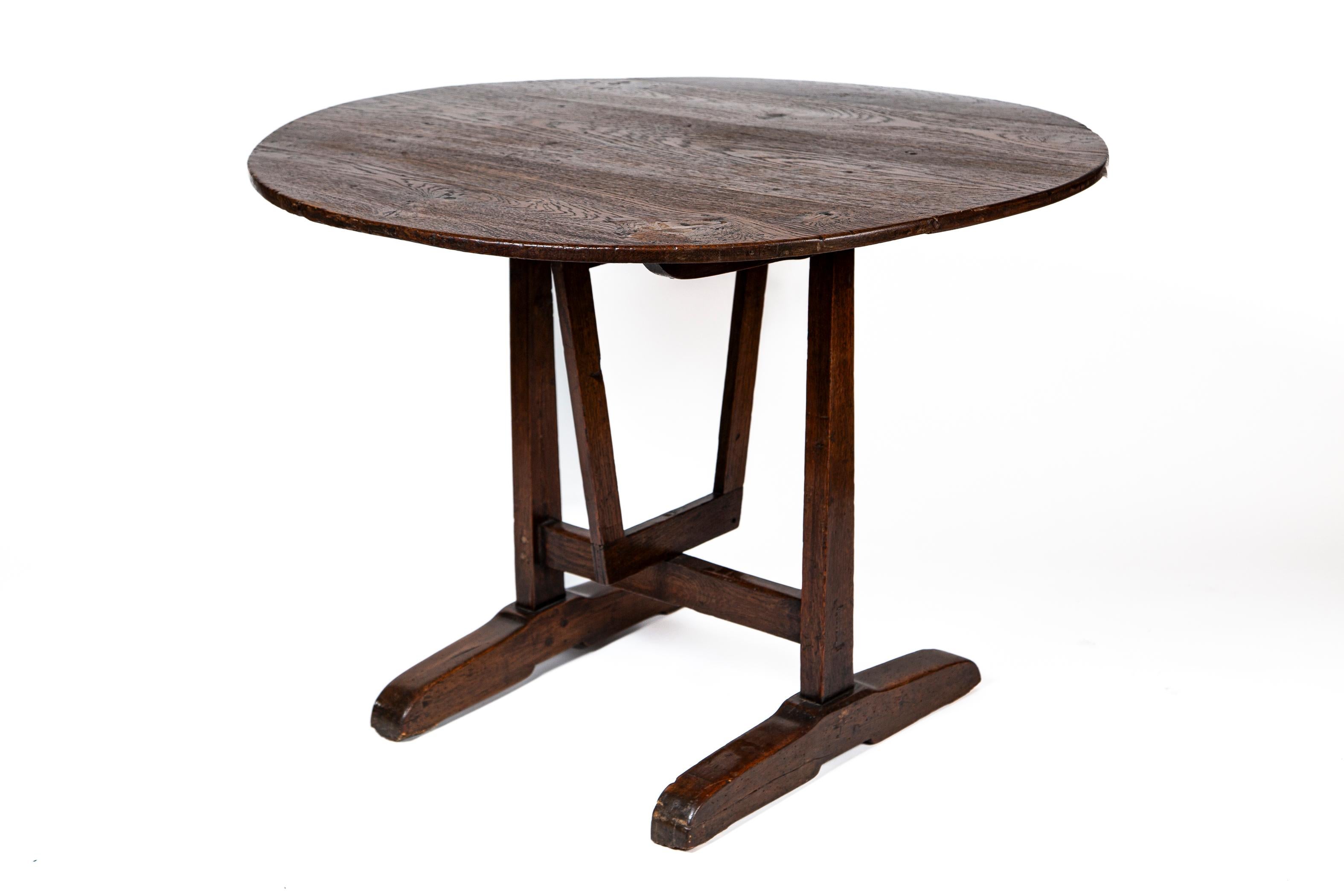 French Fruitwood Vendange (Wine tasting) Table, late 19th Century. Vendange tables were used in the cellars of vineyards throughout the wine regions. Designed with a trestle base and swivel to allow the top to drop down for storage. This table has