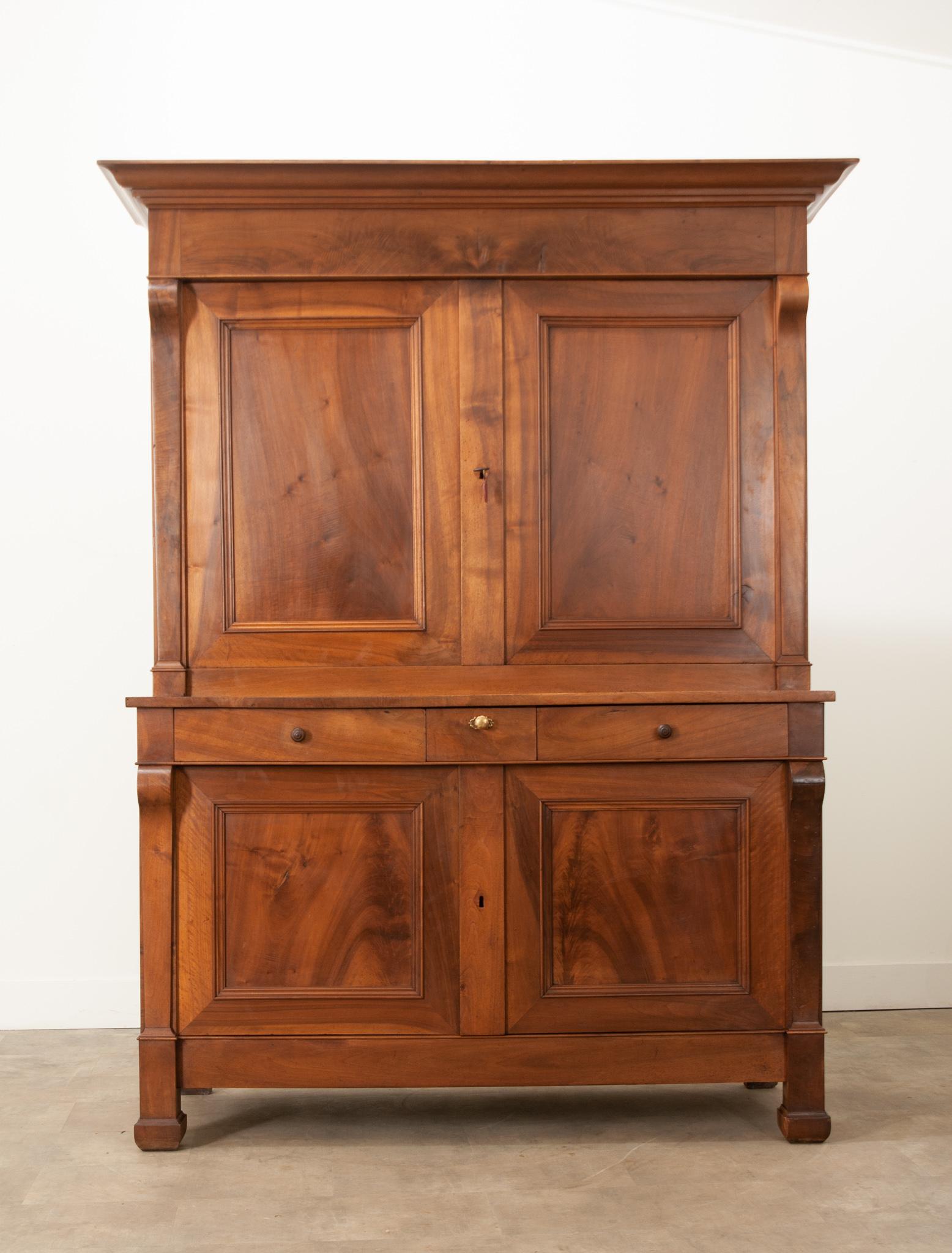 A gorgeous solid walnut buffet a deux corps, hand-crafted in the Restauration style, in 1870s France. The buffet is composed of two bodies: an upper and lower. The upper body is outfitted with two fixed shelves inside that measure 14 ¾” deep. The