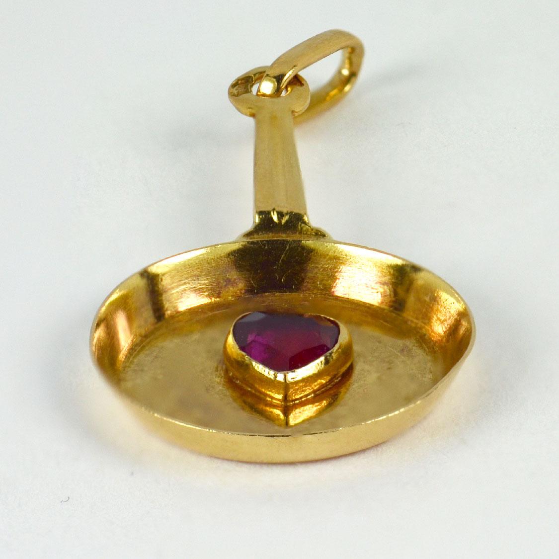 A French 18 karat (18K) yellow gold charm pendant designed as a frying pan set with a ruby heart to the centre. Stamped with the eagle’s head for 18 karat gold and French manufacture with unknown makers mark. 

Dimensions: 2.4 x 1.3 x 0.2 cm (not