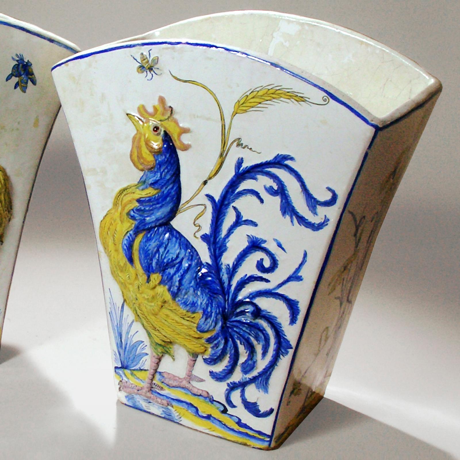 Pair of late 19th century French ceramic flared vases by the Galle pottery in Nancy, France. Designed in raised relief with crowing French cockerels in deep blue and yellow colors on a cream background. Each bird a slightly different portrait.