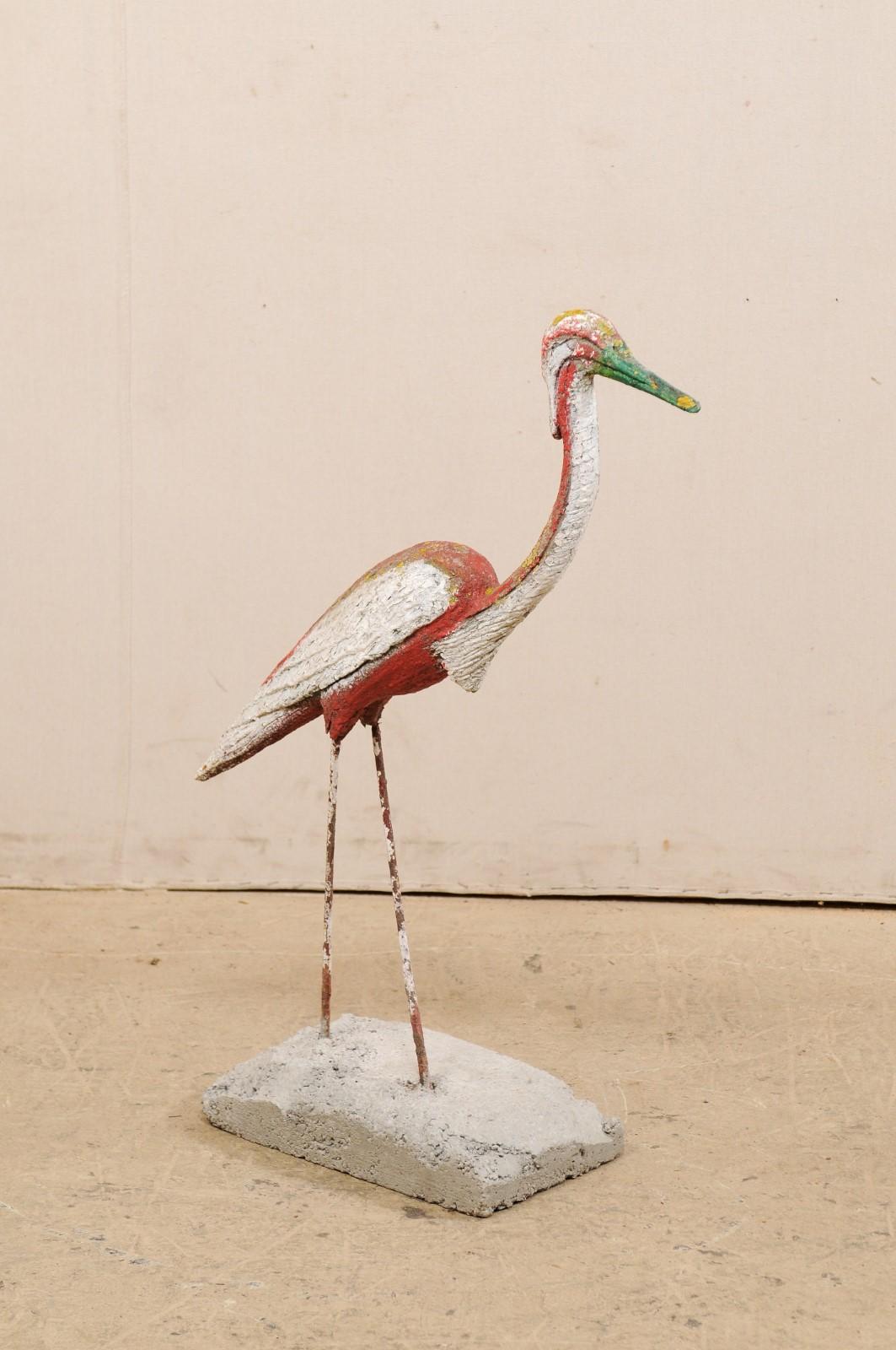 A French garden statue of a crane bird. This vintage statue from France, created in cast-stone, in the image of a crane, standing in walking position with head forward. This sculptural figure stands approximately 3 feet in height and is nicely