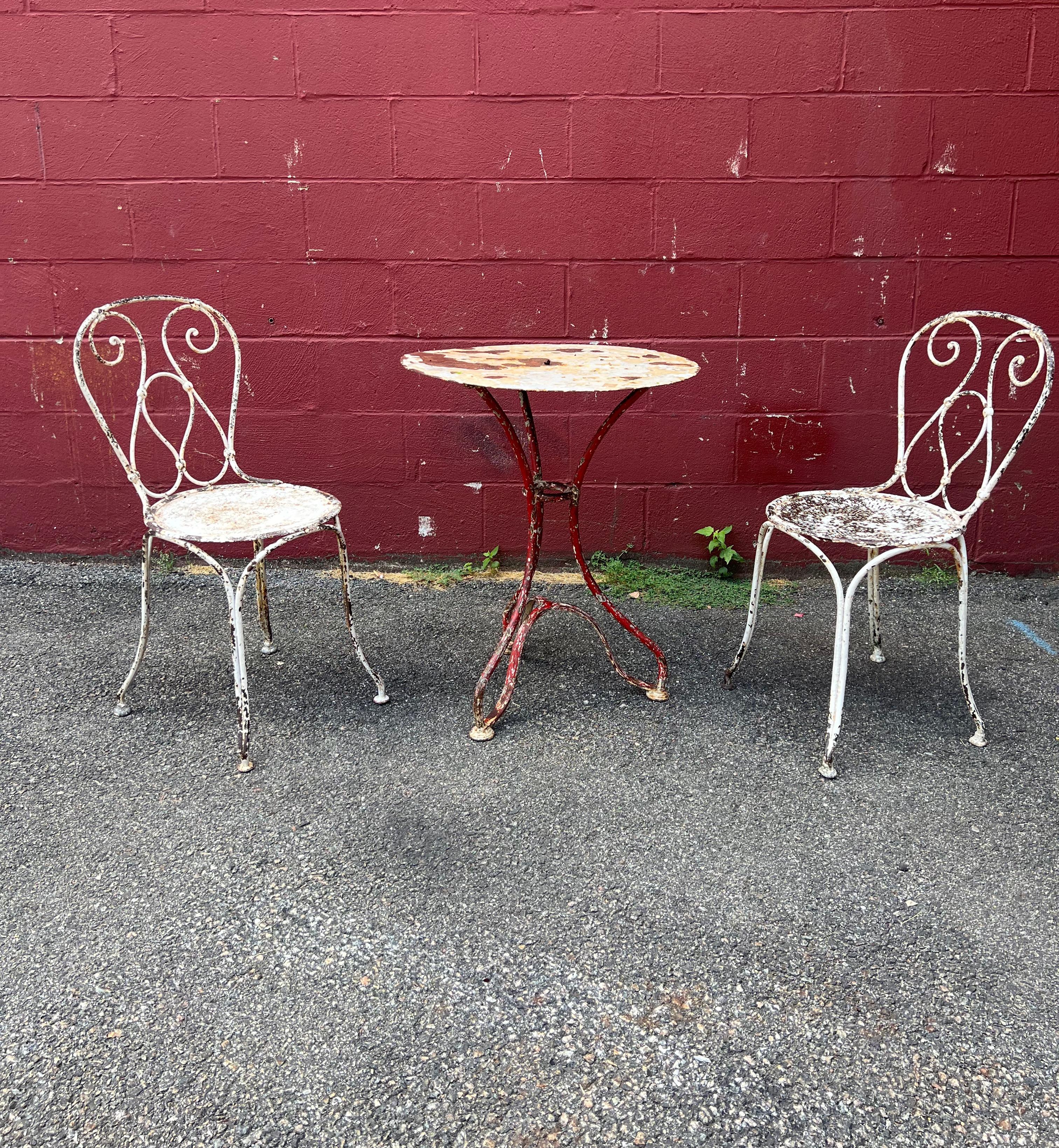 This French garden bistro table is a unique and charming piece that will add character to any outdoor space. The distressed red and white paint finish gives it a rustic and vintage look that is both stylish and functional. The white top is mounted