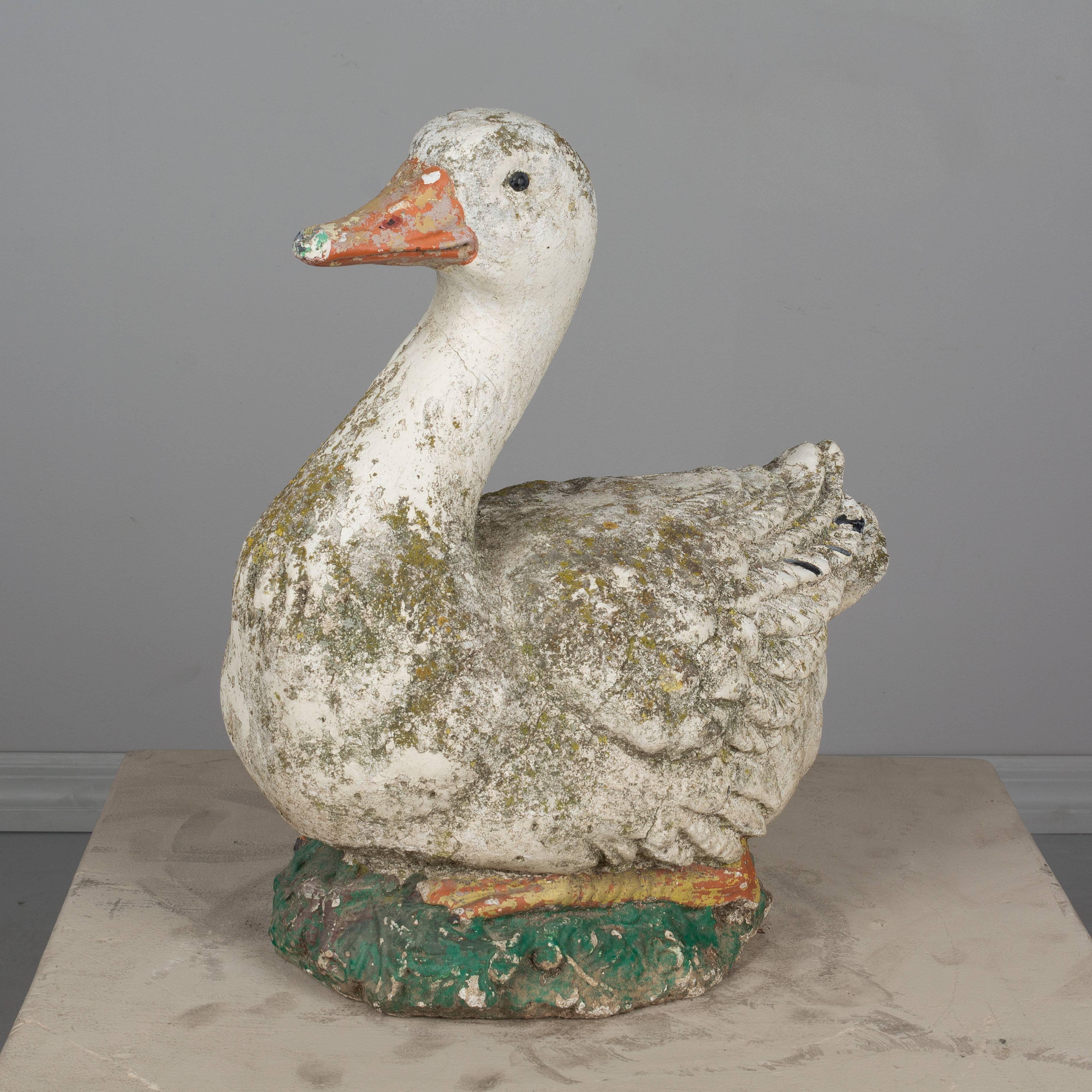 An early 20th century country French garden sculpture of a duck made of composite stone with remnants of old paint. Weight: 96 lbs. Please refer to photos for more details. We have a large selection of French antiques at Olivier Fleury, Inc.  Please