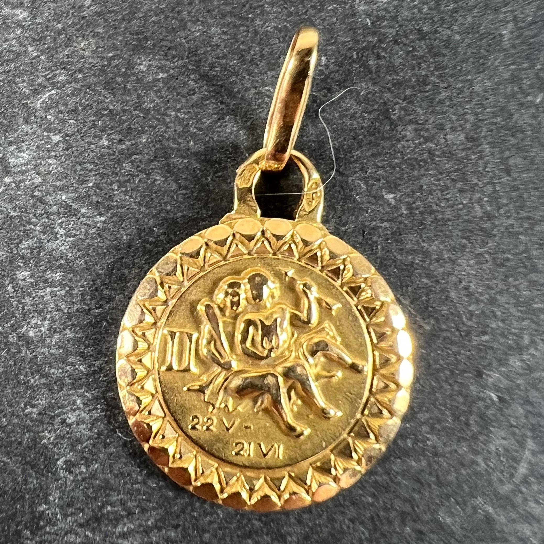 Colgante de oro amarillo de 18 quilates (18K) diseñado según el signo zodiacal de Géminis, que representa a una pareja de gemelos con las fechas 22 V (mayo) y 21 VI (junio). Estampado con la marca del águila para oro de 18 quilates y fabricación