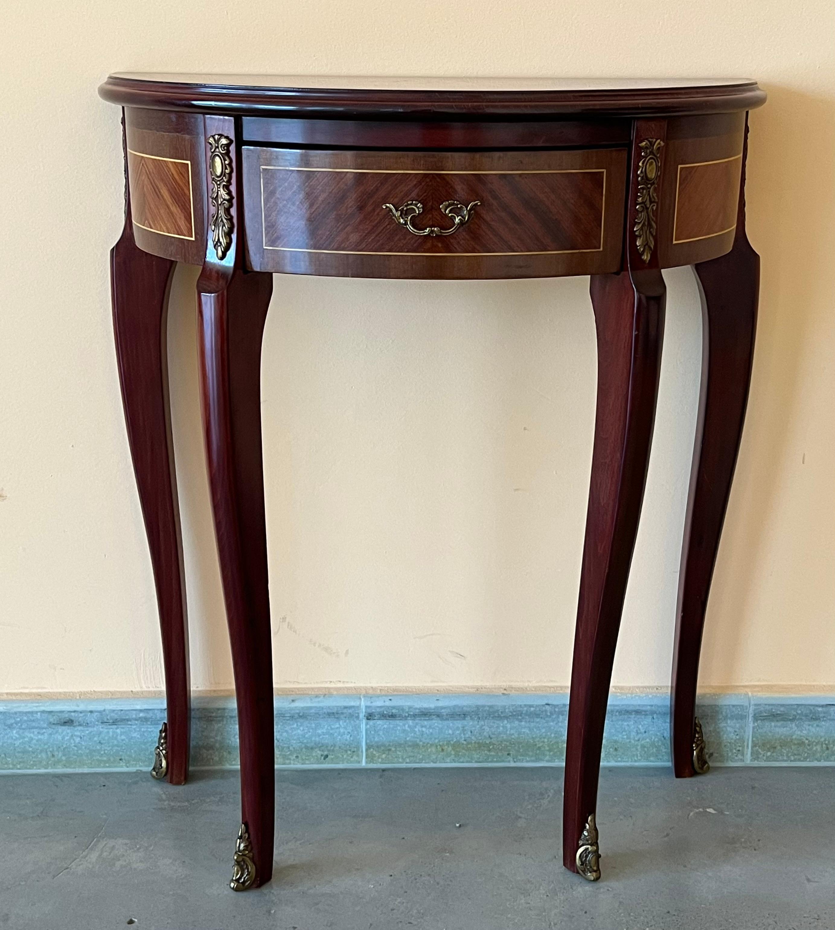 Elegant French inspired satinwood demilune console table with fine classical Floral marquetry inlay on the top, drawer and sides, raised on tapering legs with brass details.
You can use as nightstands, console, or side table.