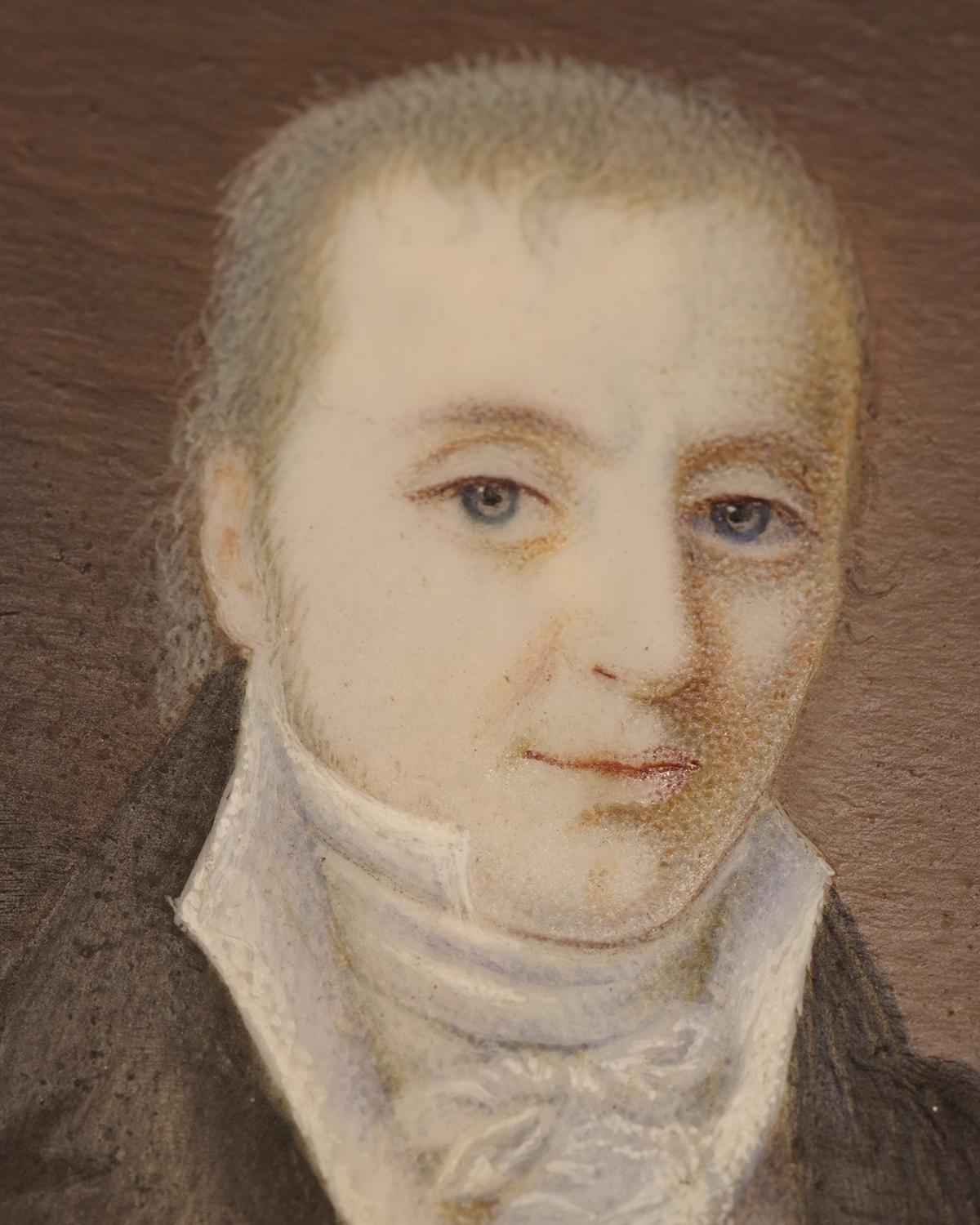 Georgian gentleman portrait pendant in 18 karat gold. Rectangular pendant enclosing a miniature portrait of a man, protected by two glass plates. The man wears a jacket with short lapels and a black coat: this style corresponds to the transition