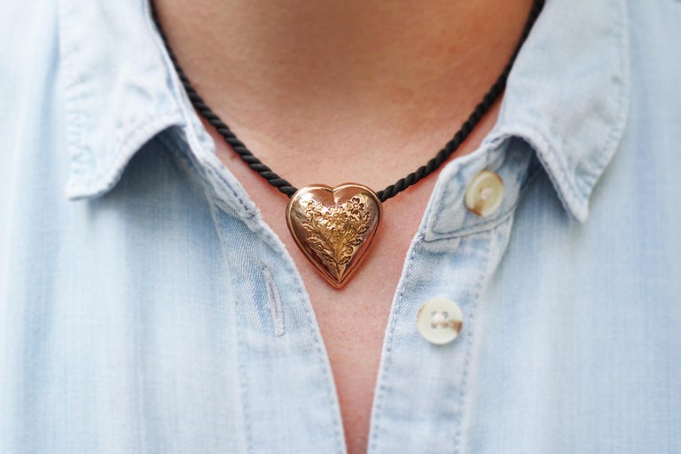 French Georgian heart pendant in rose gold 18 karats. Element of regional necklace in the shape of heart. It is in hollow gold, decorated with a stamped bouquet of flowers. The heart is curved and lets pass through on the back a black cord.