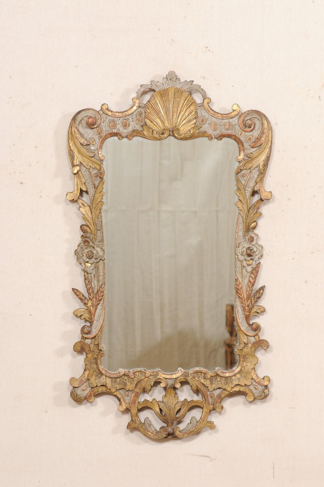 A French Georgian style carved wood mirror, with its original finish, from the turn of the 18th and 19th century. This antique mirror from France, designed with Georgian influences, features a beautifully pierce-carved wood surround in a shell and