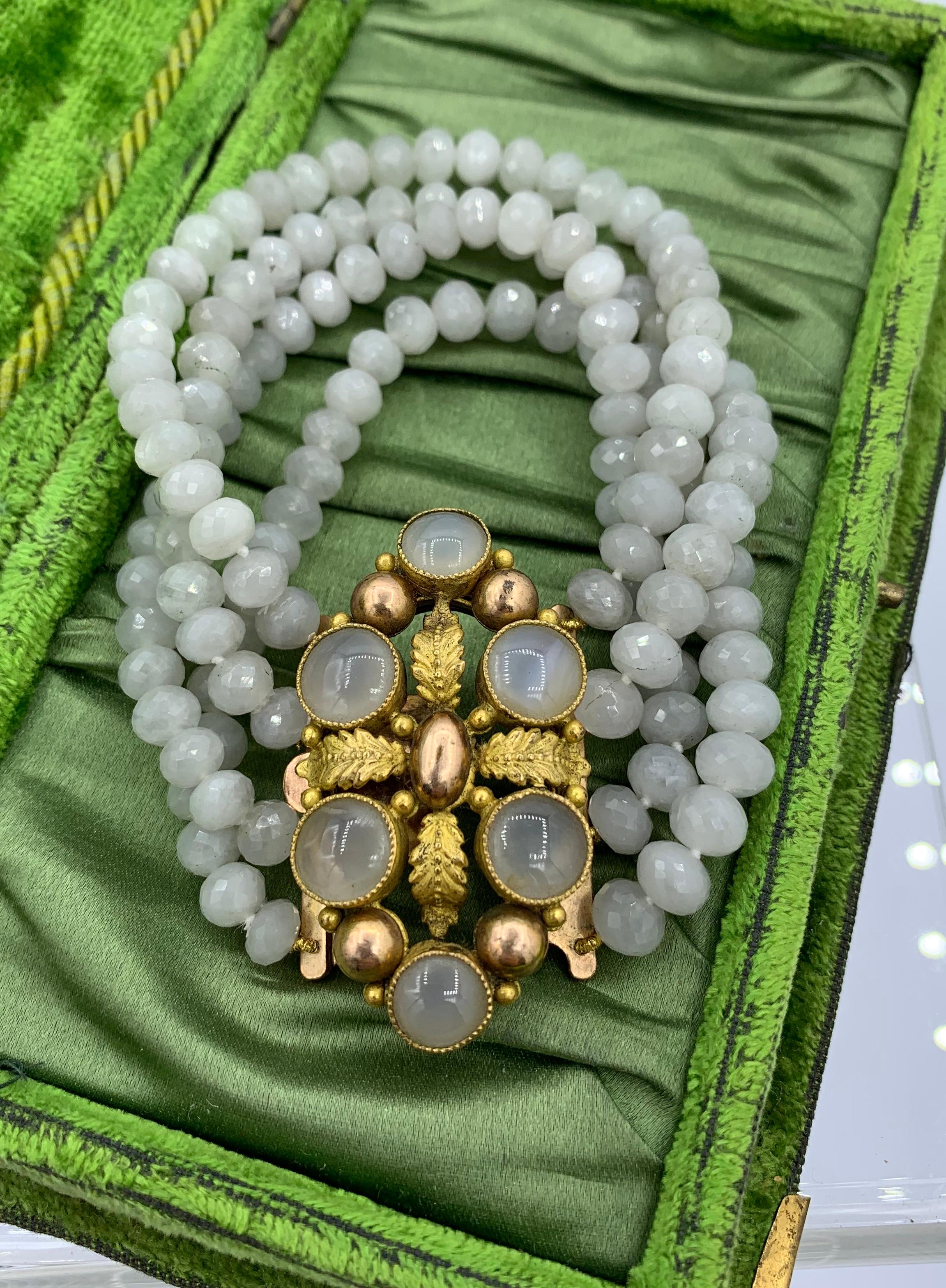 Il s'agit d'un magnifique bracelet français ancien de style géorgien - Napoléon III avec un spectaculaire fermoir central Pinchbeck serti de pierres précieuses d'agate blanche avec une bande de quatre brins de perles d'agate blanche à facettes.  Les