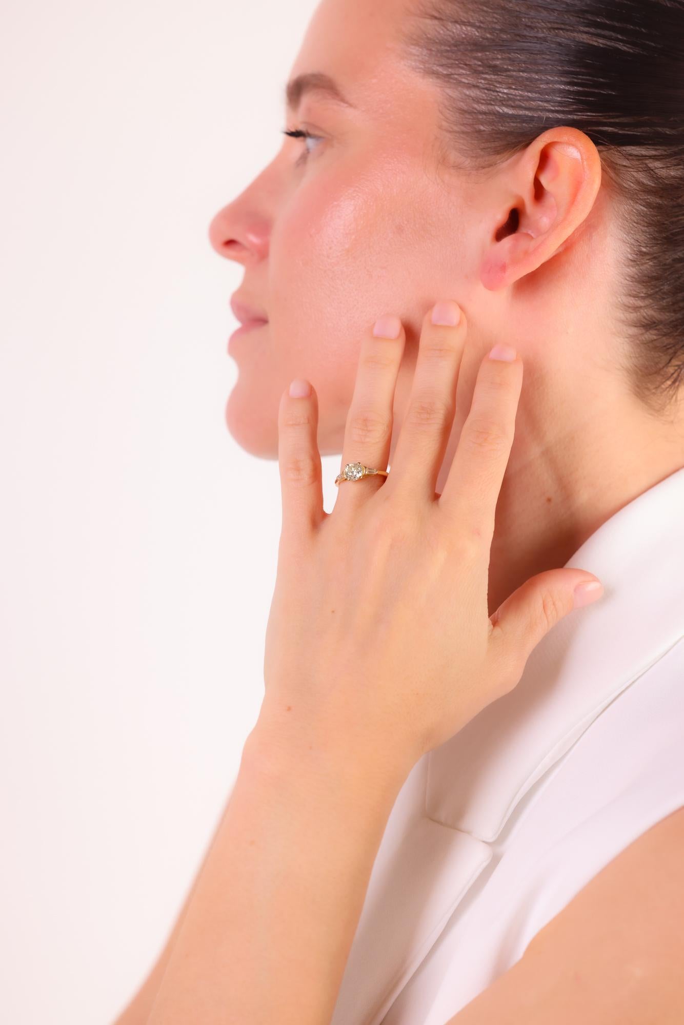 Dieser französische Verlobungsring im Vintage-Stil präsentiert einen GIA-zertifizierten runden Brillanten von 1,01 Karat mit spitz zulaufenden Baguette-Akzenten in einer eleganten Fassung aus 18 Karat Gelbgold.

Zertifikat: GIA
