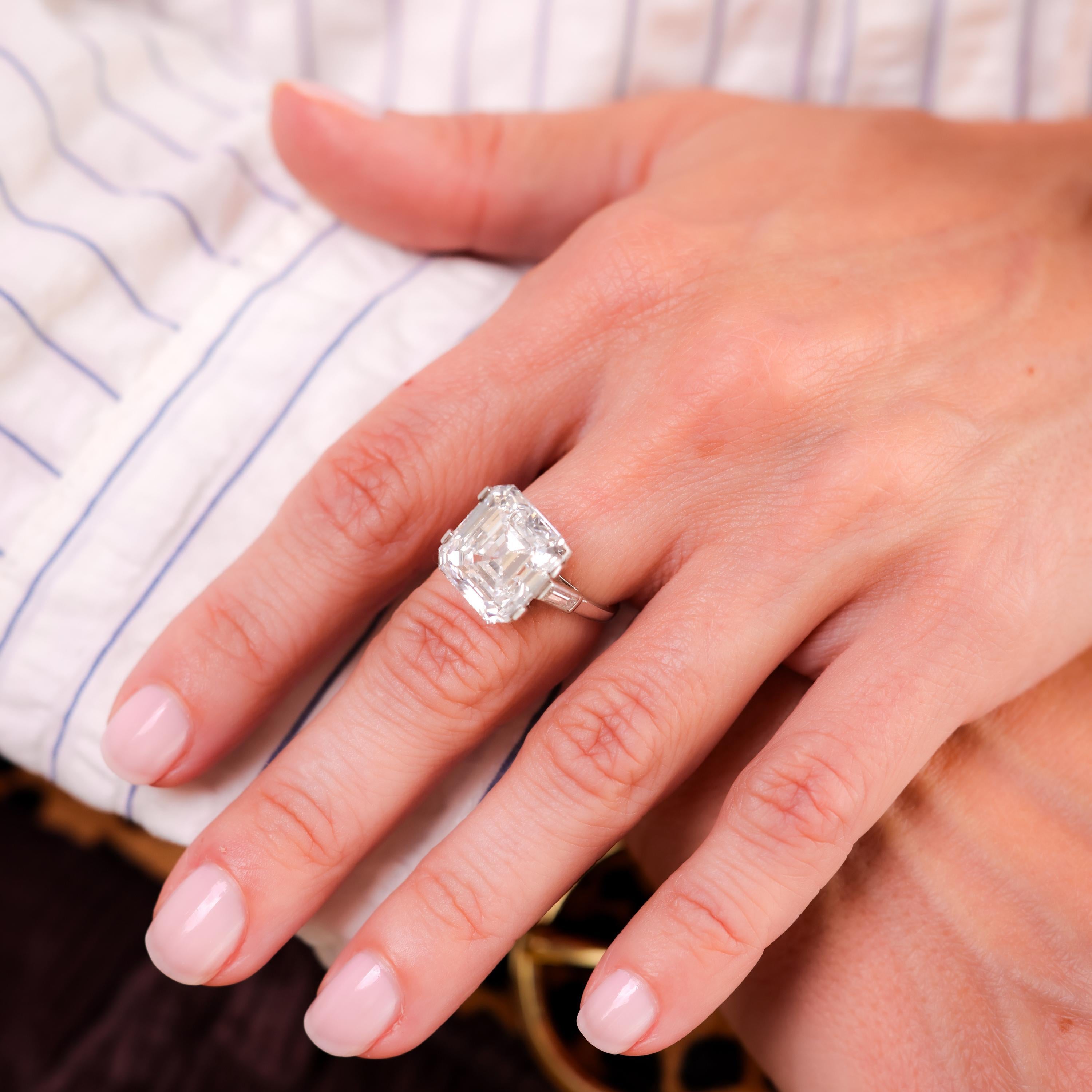 Certificate: GIA  #2225989366
Center Stone: Asscher Cut Diamond 
Weight: 10.7
Color: G
Clarity: SI2
Accent Stone: 2 Baguette Cut Diamonds
Weight: Approximately .30 Carats
Color: G
Clarity: SI
Metal: Platinum 
Era: Mid Century
Circa: 1950's