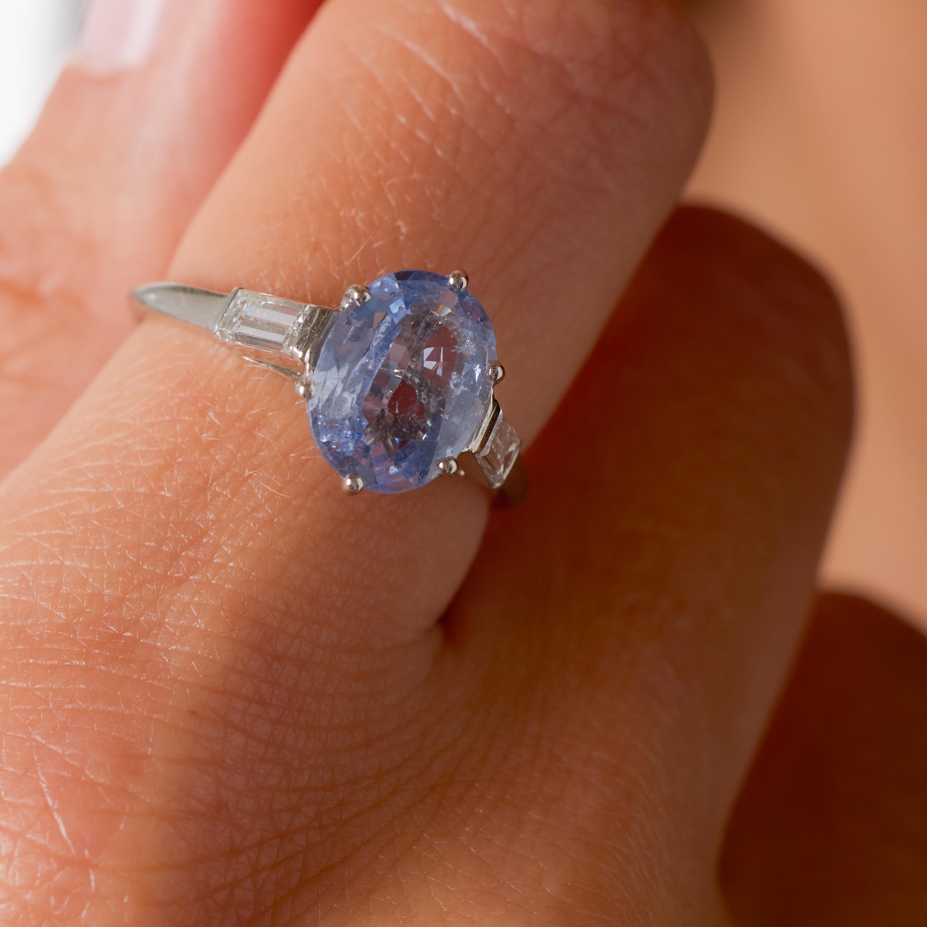 Cette magnifique bague française du milieu du siècle met en valeur un saphir bleu violette rare et naturellement vibrant de 2,31 carats, certifié par le GIA et provenant de Madagascar. Les tons riches et changeants du saphir - oscillant entre le