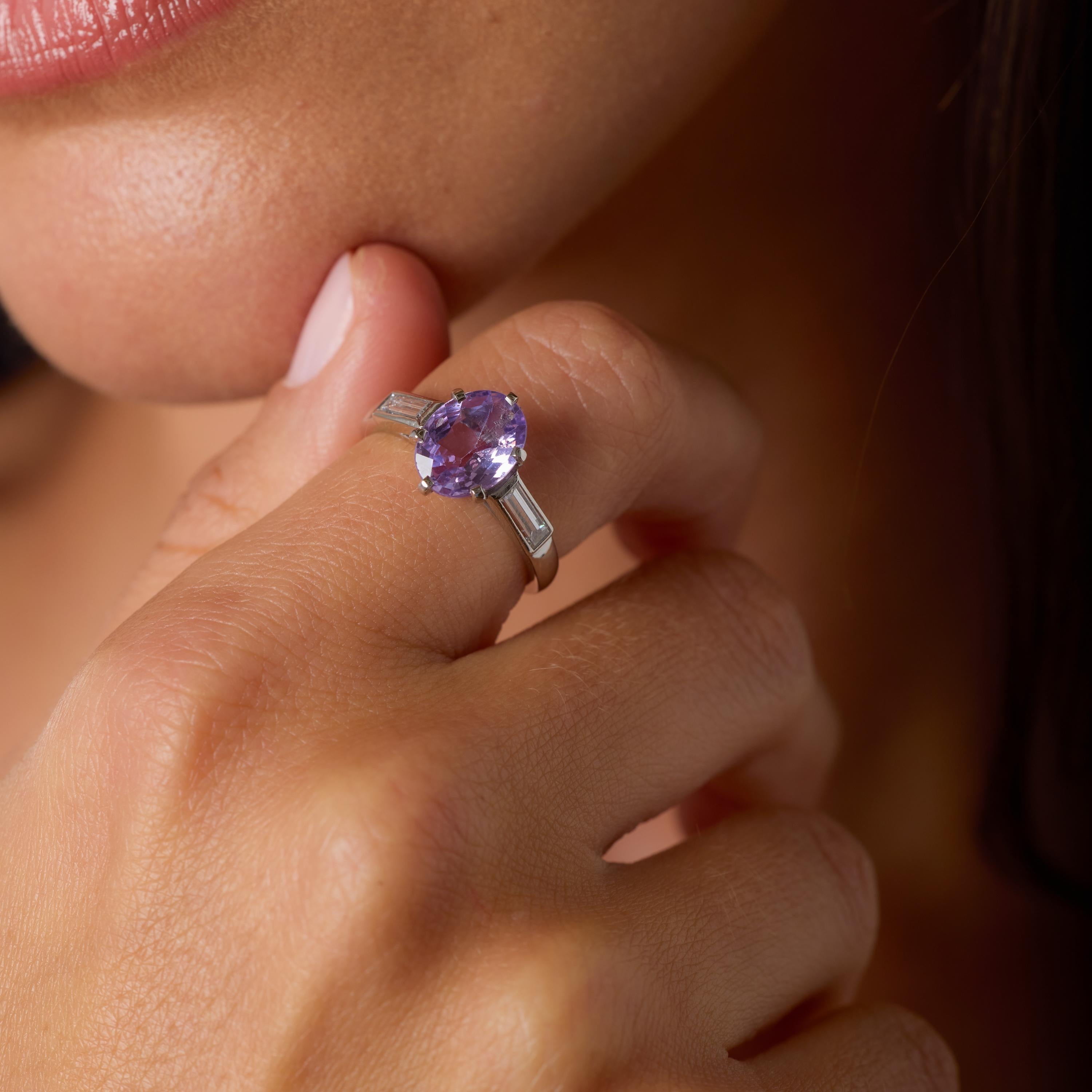 Cette exquise bague française du milieu du siècle présente en son centre un rare et époustouflant saphir violet sans chaleur - une gemme malgache de 2,45 carats certifiée par le GIA pour sa beauté naturelle et non traitée. Le saphir ovale rayonne