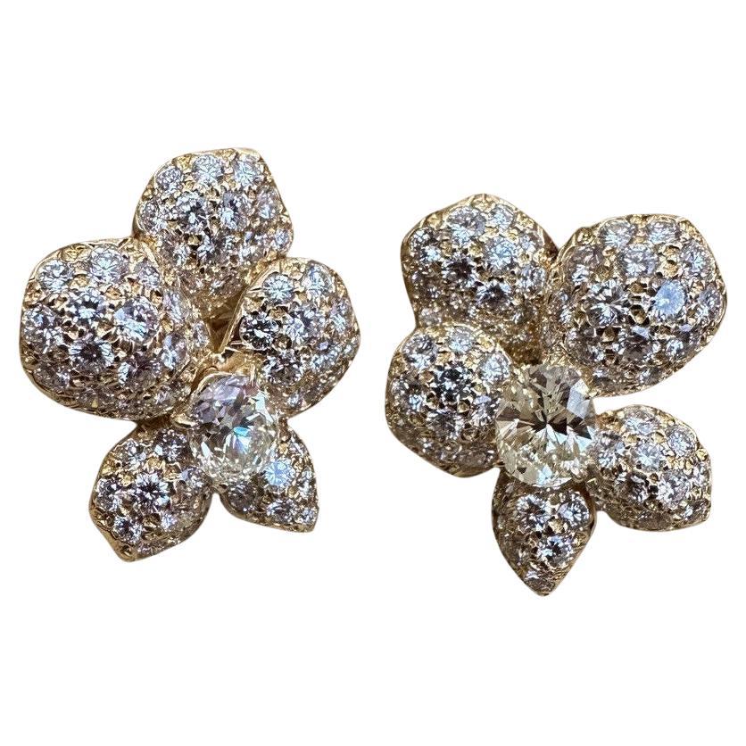 FRENCH GIA-zertifizierte Diamant-Pavé-Ohrringe mit asymmetrischer Blüte aus 18k Gelbgold

Asymmetrische Blumenohrringe mit 2 ovalen Brillanten, umgeben von Pavé-Diamanten, die ein Blumendesign in 18k Gelbgold bilden.

Die beiden mittleren Diamanten