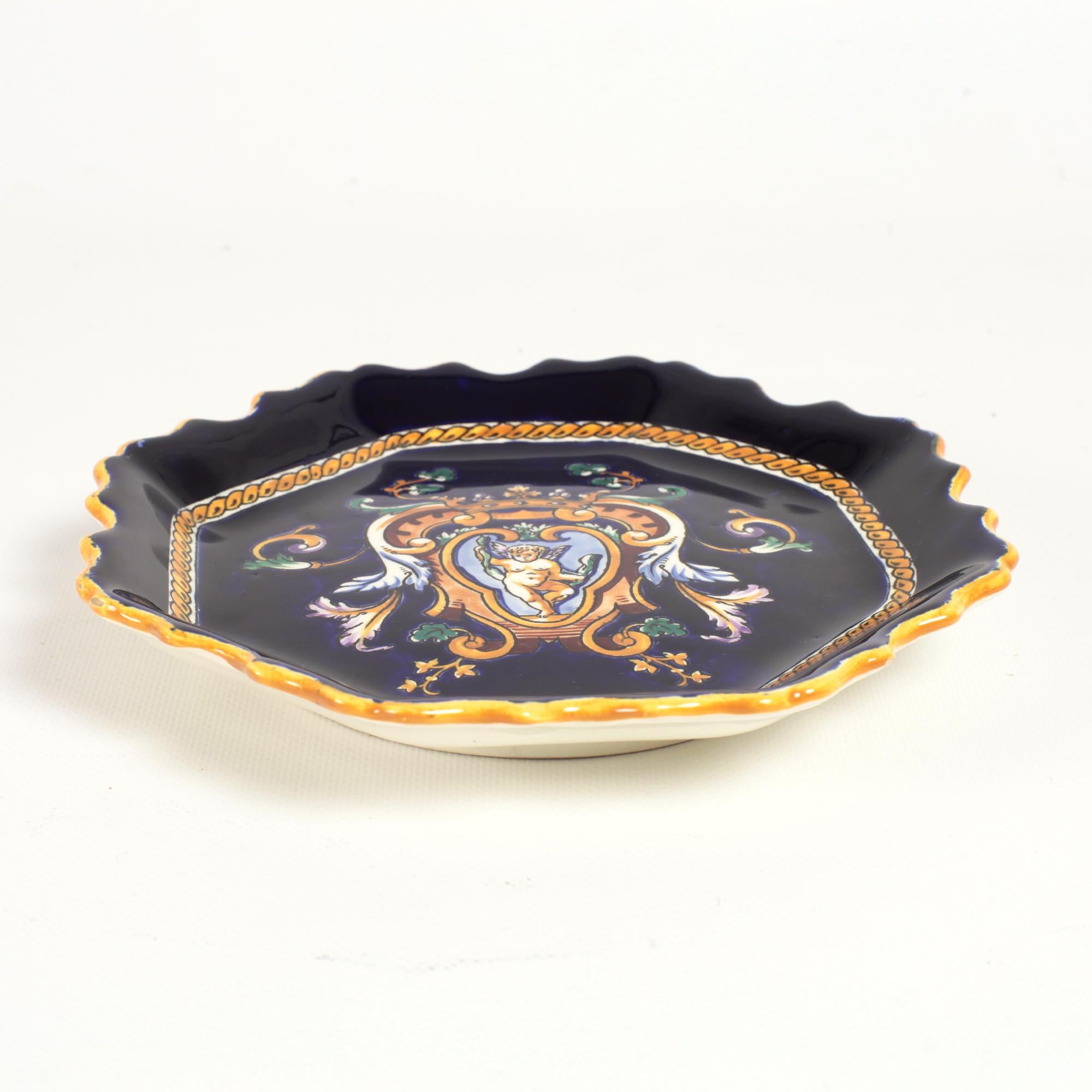 Charming hanging plate from Gien with cobalt blue background for hand painted grotesque decorations inspired by fifteenth-century Italy.
The motifs in yellow, white and brown highlights depict chimeras, scrolls, bearded men, masks, children.
This