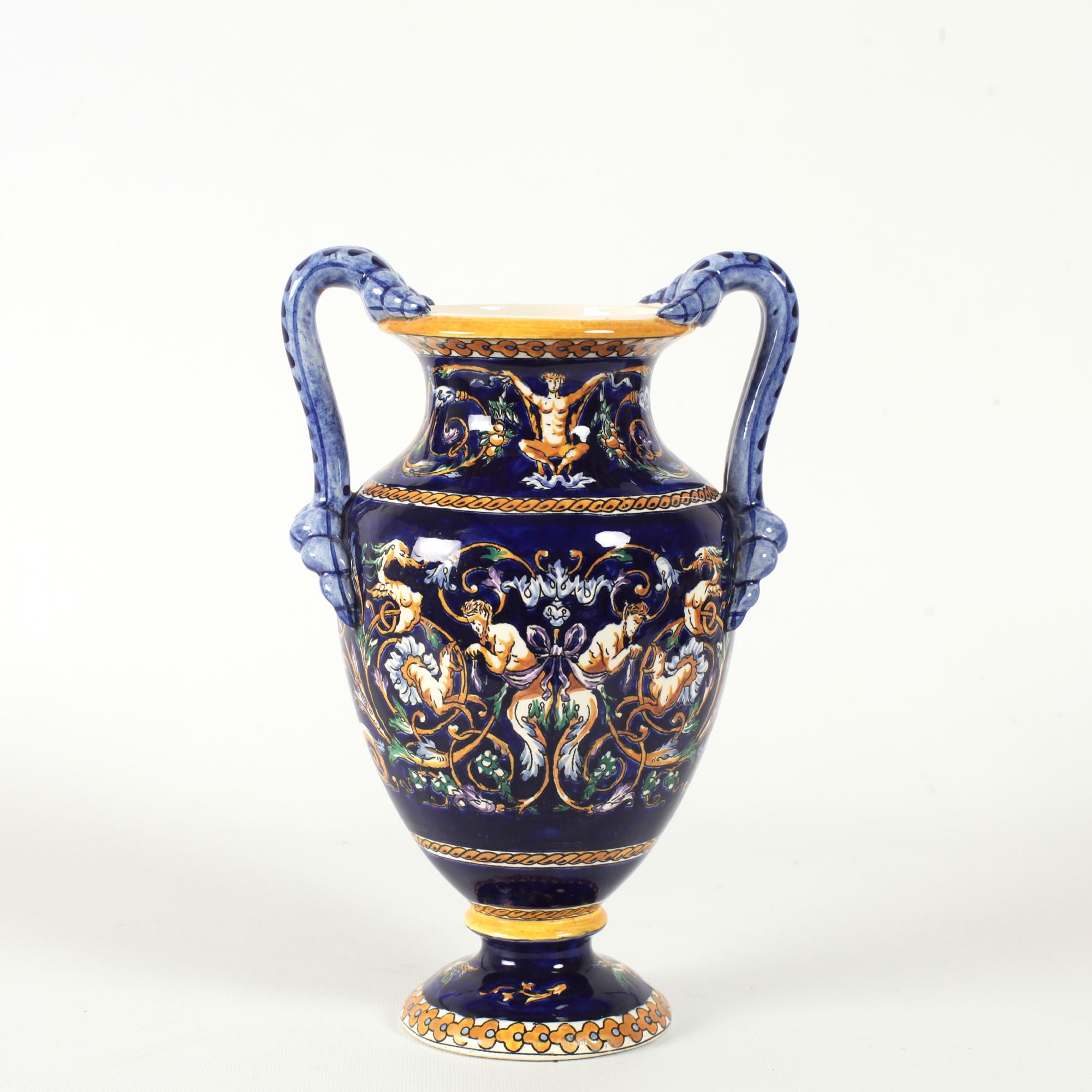 Elegant vase is round in shape and stands on a circular base with cobalt blue background for hand painted grotesque decorations inspired by fifteenth-century Italy. The motifs in yellow, white and brown highlights depict chimeras, scrolls, bearded