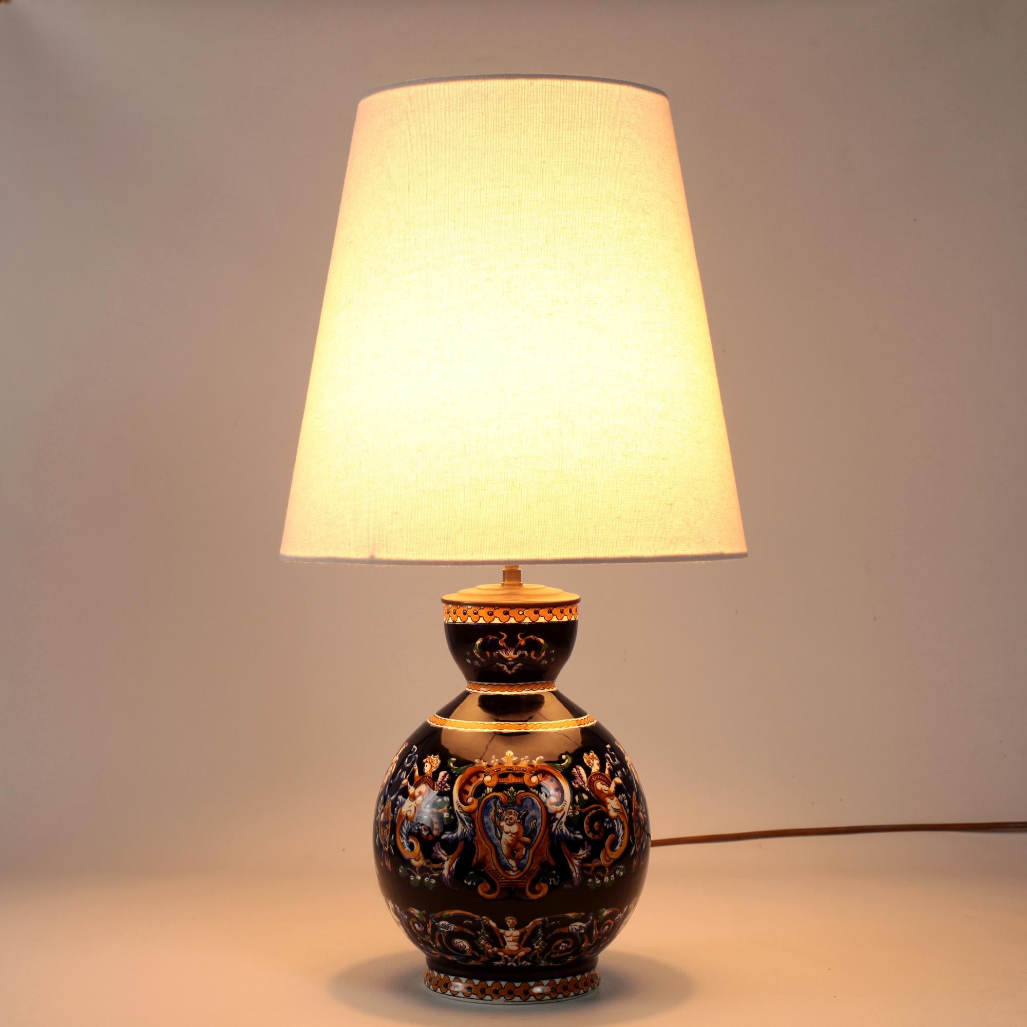 Elegant table lamp from Gien with cobalt blue background for hand painted Renaissance grotesque decorations inspired by fifteenth-century Italy.
The motifs in yellow, white and brown highlights depict chimeras, scrolls, bearded men, masks,