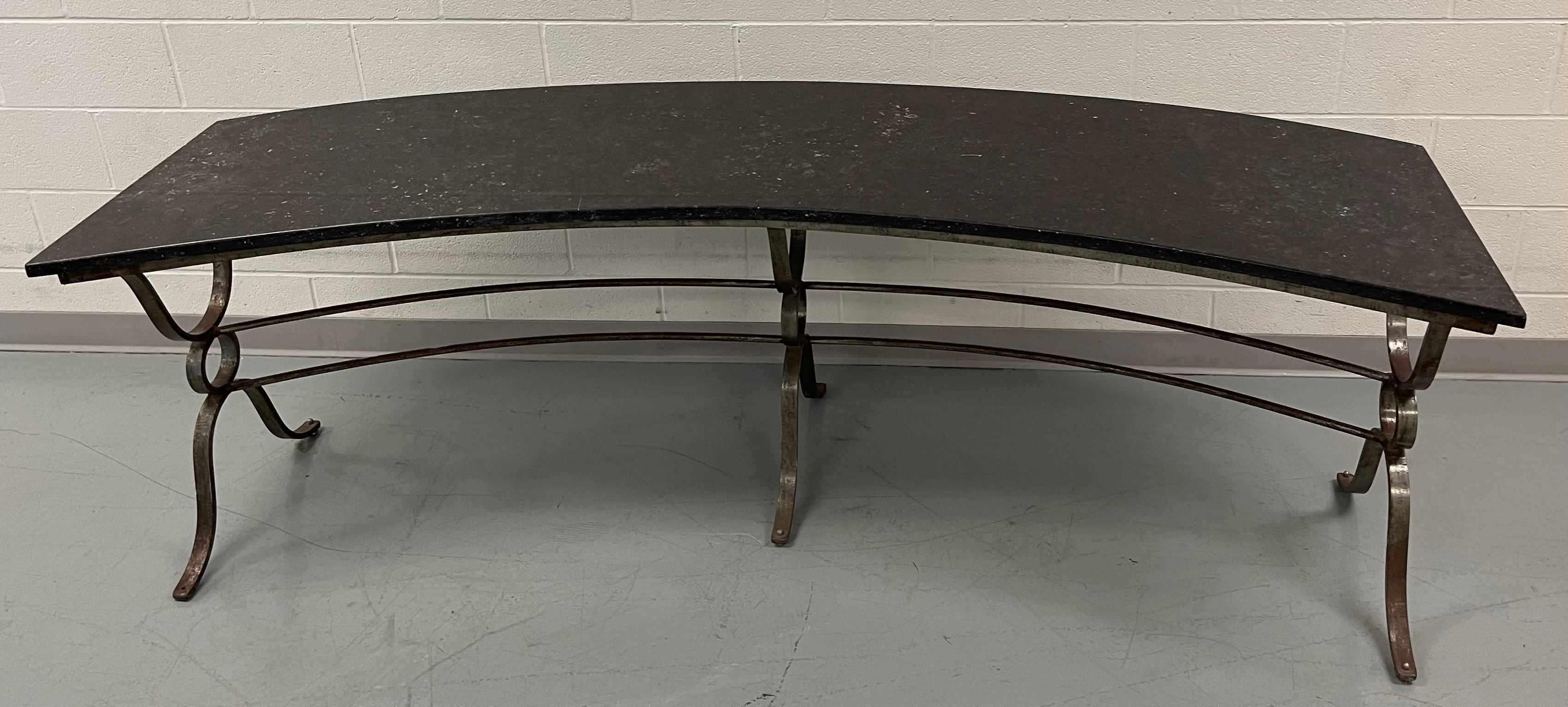 1930s French Gilbert Poillerat style large console table. Curved Demi lune style table with wrought iron base and black marble top. 
This table is well made and extremely heavy. Perfect for a large entry way, or could be used as a desk or plant