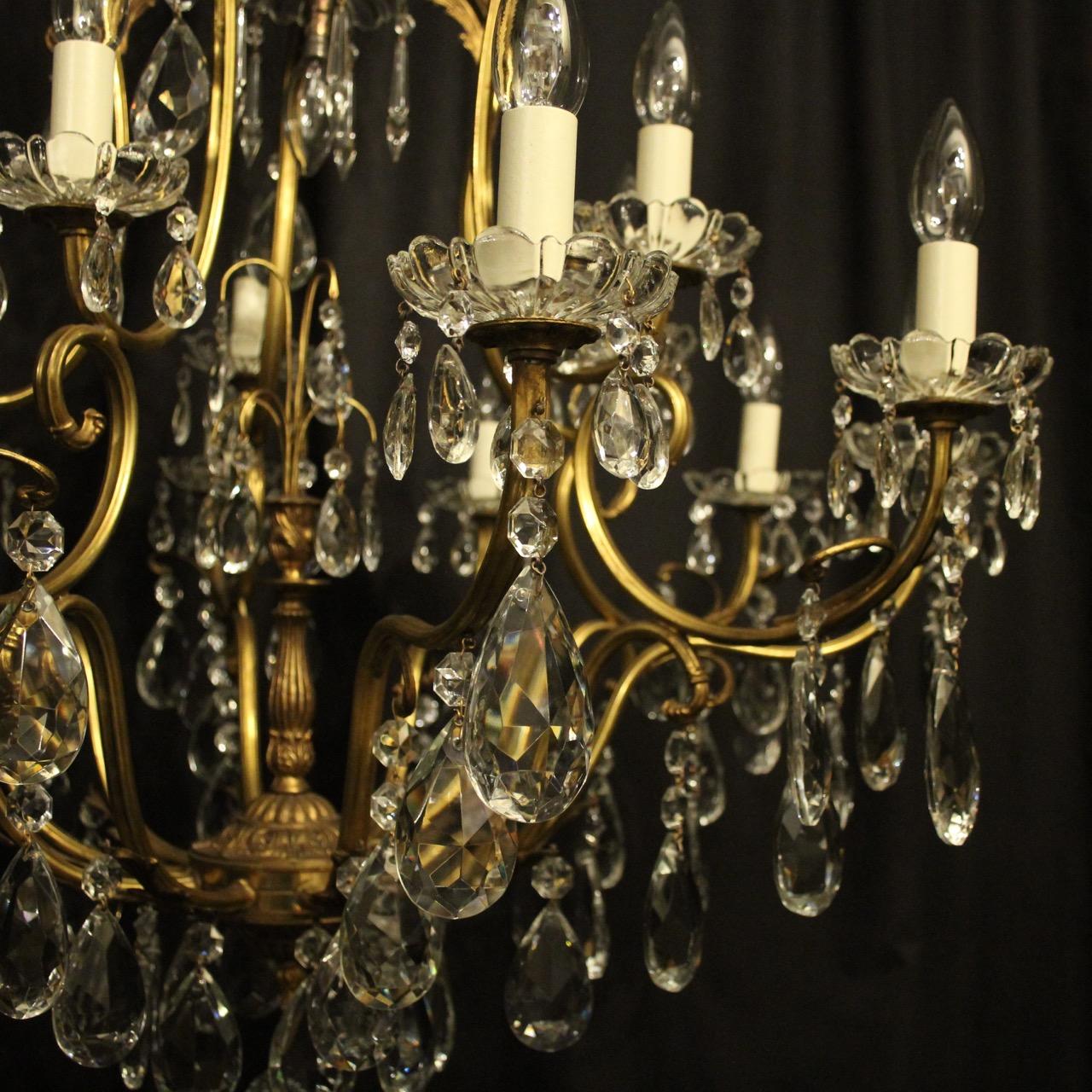 A French gilded brass and crystal 16-light birdcage form antique chandelier, the fifteen tiered leaf clad scrolling arms with glass bobeche drip pans, issuing from a foliated cage form interior with a single inverted light fitting and wirework