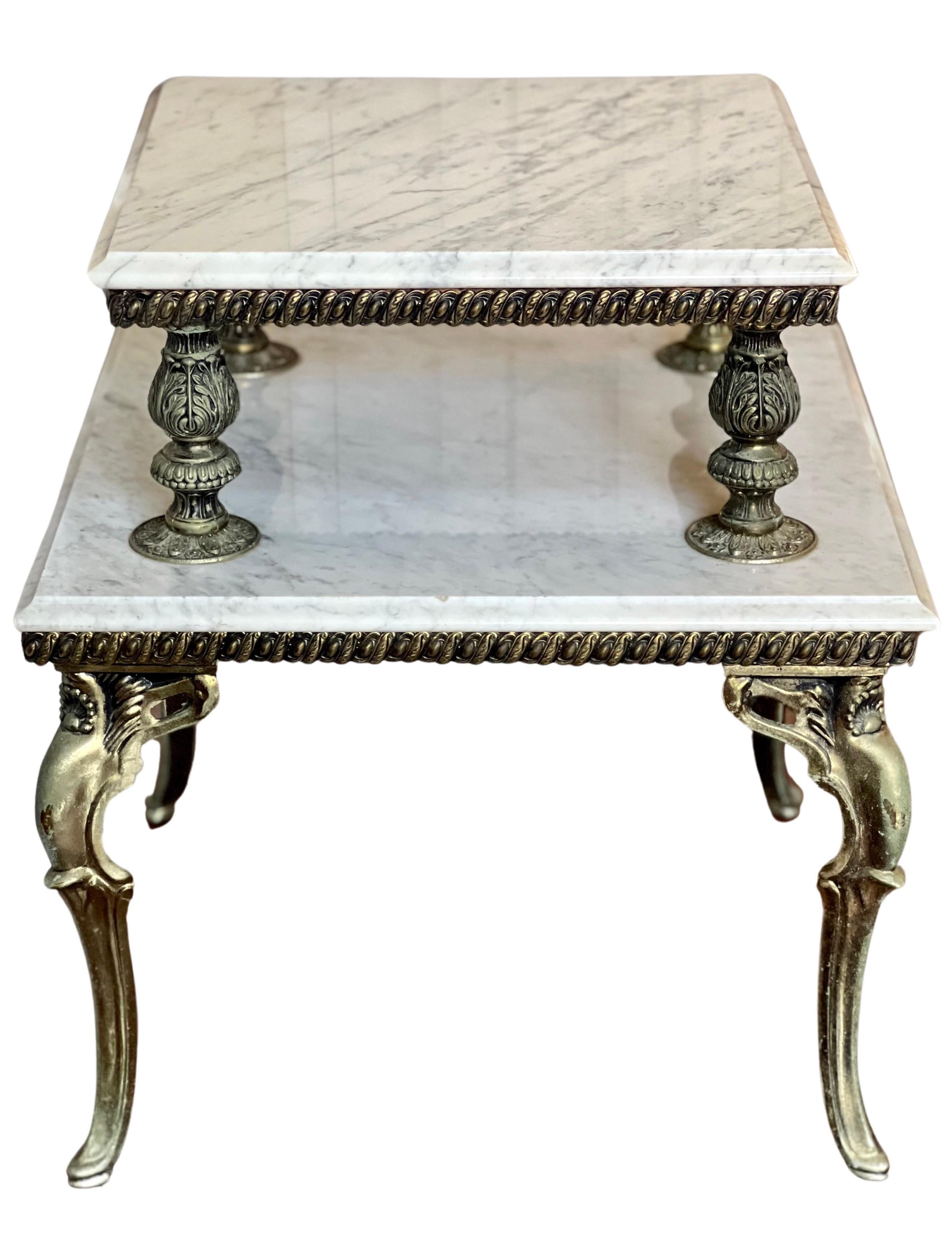 Carrera marble and gilded brass two tier side table, France circa 1940's.

Elegant Hollywood Regency style table featuring two beveled marble tiers atop graceful cabriole legs with acanthus leaf and shell motifs. Finely detailed balustrade form
