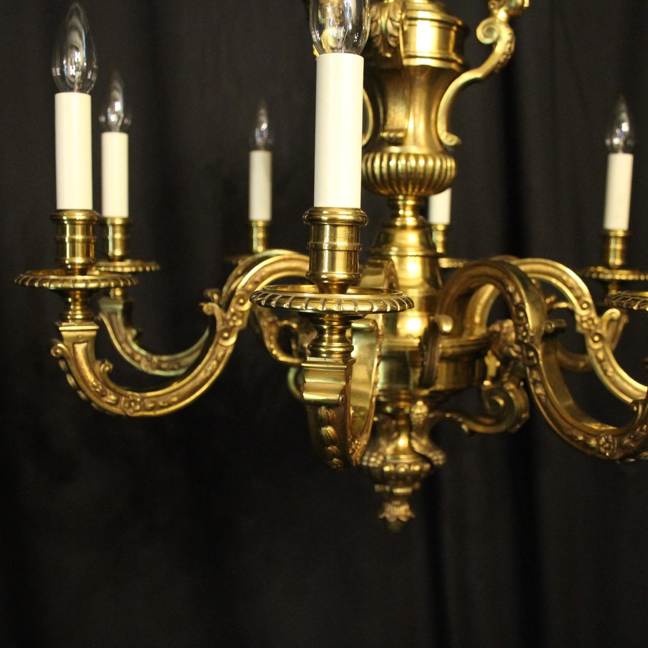 A French gilded bronze 8-light antique chandelier in the manner of Andre Charles Boulle, the leaf clad square gauge scrolling arms with ornate circular bobeche drip pans and reeded candle sconces, issuing from a pierced central urn stem with four