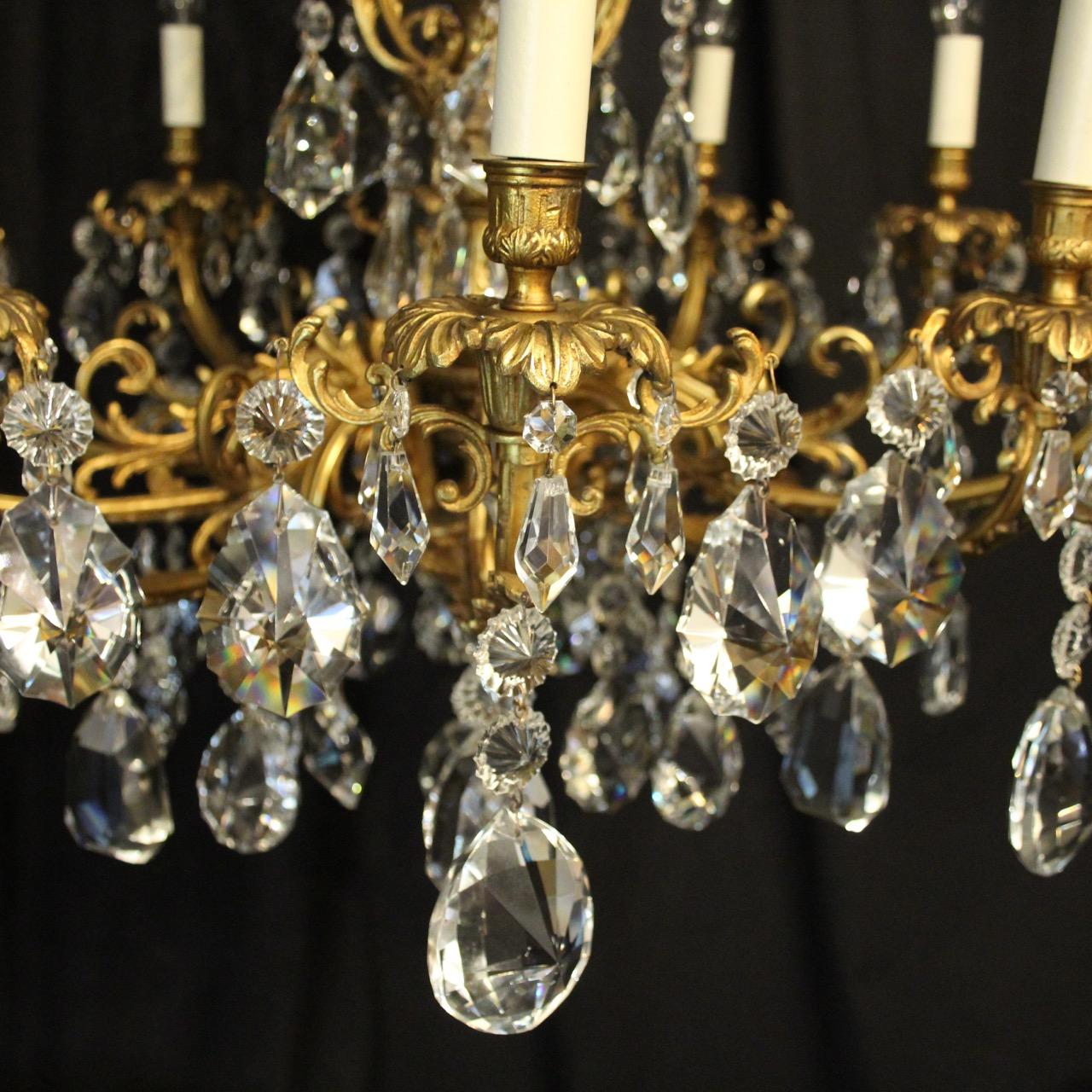 A quality French gilded bronze and crystal ten-light antique chandelier, the ornate acanthus leaf scrolling arms with trumpet reeded bobeche drip pans and bulbous candle sconces, issuing from an foliated central column with an elaborate mid and top